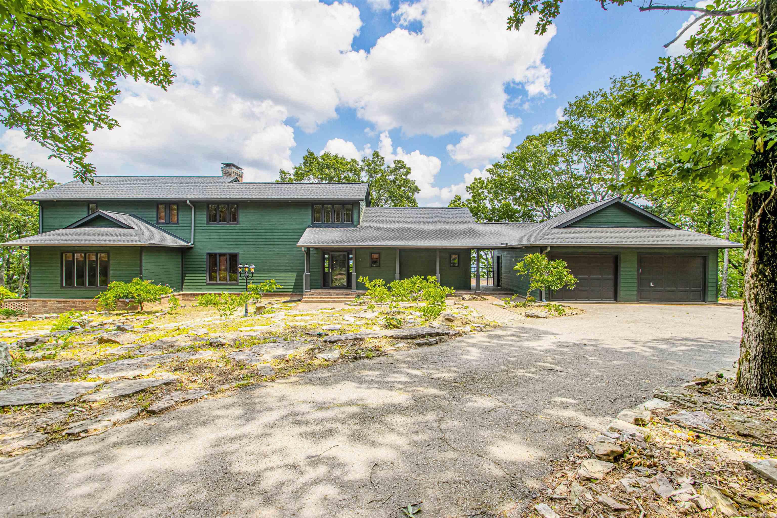 Nestled atop Petit Jean Mountain with panoramic views of the Arkansas River Valley, this custom 4-bed, 3.5-bath retreat blends rustic charm with modern comfort. Set on 2.51 wooded acres, this 3,255 sq ft home features soaring ceilings, hardwood and tile floors, and abundant natural light. The spacious living area centers around a gas-log fireplace and a wall of windows framing breathtaking scenery. The kitchen offers granite tile counters, stainless appliances, ample cabinetry, and flows seamlessly into a dining space overlooking the valley. The primary suite boasts vaulted ceilings, a private balcony, and a spa-like en-suite. Upstairs includes additional bedrooms, a charming bunk room, and a bonus loft for relaxing or entertaining. Step onto the expansive deck for unforgettable sunsets and outdoor living. Minutes from Petit Jean State Park, this home is perfect as a full-time residence, vacation home, or short-term rental.
