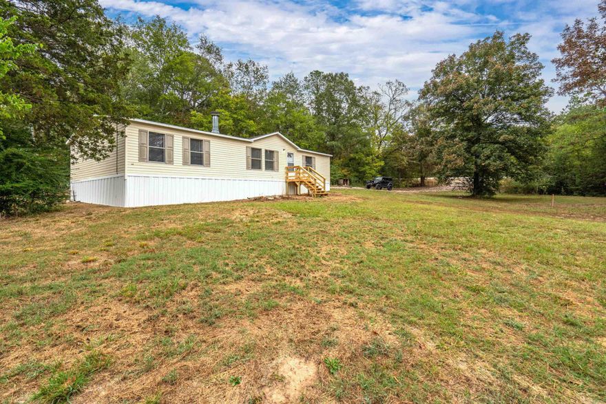 This charming 3 bedroom 2 bath  mobile home with new flooring, new paint, fireplace and open concept  offers the best of both worlds: the tranquility of rural living and easy access to nearby amenities. Whether you're seeking a peaceful retreat, a place to call home, or a weekend getaway, this property is a fantastic opportunity.  Don't let this chance slip away. Embrace the serenity of country living and make this  home your own. Contact us today to arrange a viewing and experience the charm of this country oasis.