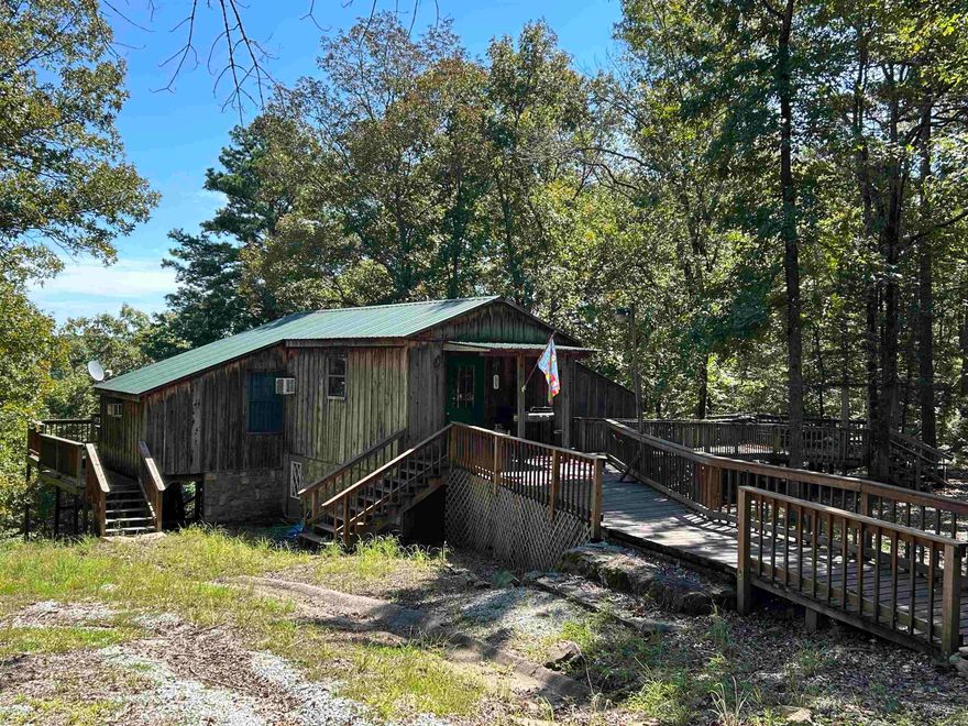 Located on a spacious lot with stunning seasonal views of Greers Ferry Lake, this charming property offers a peek of the water in summer and a breathtaking reveal of a lake island when autumn leaves fall. Surrounded by natural rock formations, the home features a large deck perfect for entertaining or soaking in the serene scenery. The lower level includes a basement room ripe for remodeling to suit your vision—ideal for a cozy retreat or extra living space. An outdoor storage shed provides ample room for lake gear, and the property’s prime location is just minutes from Frontier Canyon boat ramp, ensuring easy access to boating and lake adventures. Embrace the beauty and potential of this unique Lakeview Property!