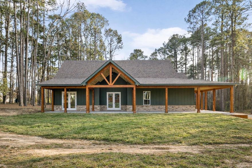 NEW CONSTRUCTION ON 1.8 ACRES IN TOWN! Feel like you have escaped to your own VRBO every day in this rustic charmer with over 1200 square feet of covered porches. Living room features cathedral ceiling with hand sawn wood and wood burning fireplace. Open kitchen with walk in pantry, breakfast bar, refrigerator, and spacious dining area. Primary suite features wood ceiling, double vanities, free standing tub, custom tile shower and large walk in closet. Two other bedrooms with shared bath along with half bath on main level. Upstairs is spacious bonus room, full bathroom, and bedroom. Oversized garage and spacious laundry room with sink. Flat usable lot with mature trees and view of pond. 5 minutes to Military road!