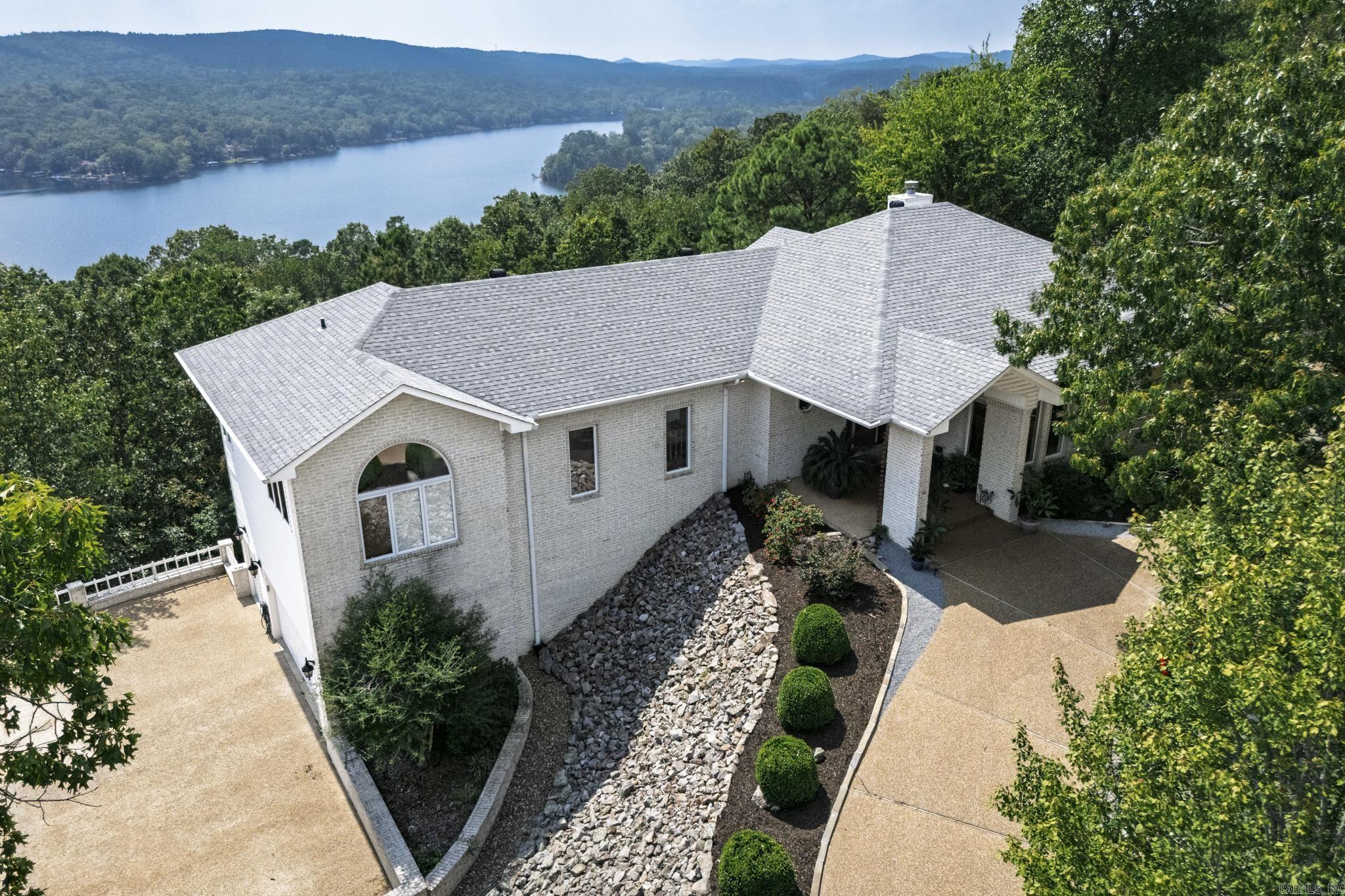 Stunning mountain vista home with amazing views of the Ouachita Mountains in beautiful Hot Springs Village. The vaulted living room ceiling, featuring large glass windows, provides panoramic mountain views. The circular driveway invites you into this stately and well-maintained home. Two master bedroom suites on the main level and two bedrooms on the lower level afford ample room for family and guests. Dishwasher, sink, and disposal 2023. Rebuilt composite deck 2022. Roof 2019. Maini level HVAC 2023, lower level HVAC 2022. Hot Springs Village has a one-time buy-in fee of $2,000 paid at closing.