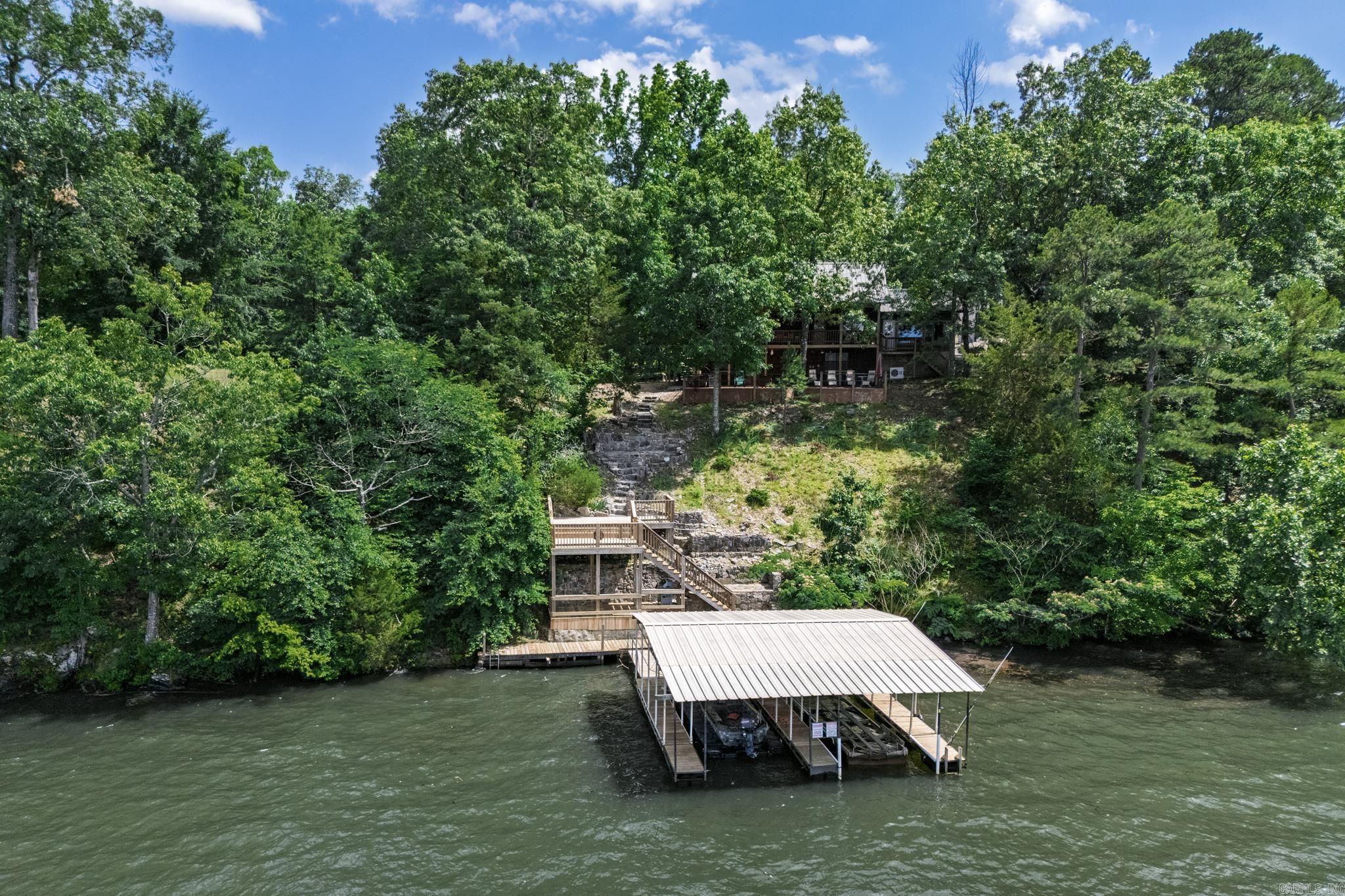Welcome to your dream home on Lake Hamilton, where modern elegance meets serene lakefront living. This beautifully remodeled three-bedroom, two-bathroom residence, updated in 2018, boasts a brand new metal roof and a spacious primary suite that offers breathtaking views of the lake, complete with an oversized shower and a luxurious soaking tub. The home features a generous multi-level back deck, perfect for entertaining or simply enjoying the stunning surroundings, leading down to a private boat dock. Complementing the property is a massive three-bay shop, providing ample space for hobbies and storage. The entire property is fully fenced, ensuring privacy and security while enhancing the beauty of this absolutely stunning lakeside retreat. Experience the perfect blend of comfort, style, and outdoor adventure in this exceptional home.