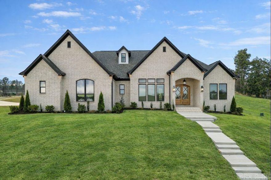 LAKE HAMILTON VIEWS ABOUND IN THIS NEW CONSTRUCTION HOME IN GATED COMMUNITY JUST MINUTES FROM OAKLAWN! Step inside to soaring spaces filled with natural light, an inviting living room with built-ins and a gas fireplace, and an open kitchen featuring a quartz island, breakfast bar, huge walk-in pantry, and expansive dining area. The primary suite is a showstopper with cathedral ceiling, spa-worthy freestanding tub, custom tile shower, and a massive walk-in closet that connects to the laundry room. A stunning office with 12-foot ceilings, French doors, and incredible lake views makes working from home a dream. Upstairs offers a versatile bonus room or bedroom with full bath and private balcony overlooking the water. Enjoy outdoor living with a covered porch, plus a 3-car garage, mudroom, and private neighborhood boat launch—all with hardwood floors, designer lighting, and top-tier finishes throughout. There is also a green space directly across that leads to the water!