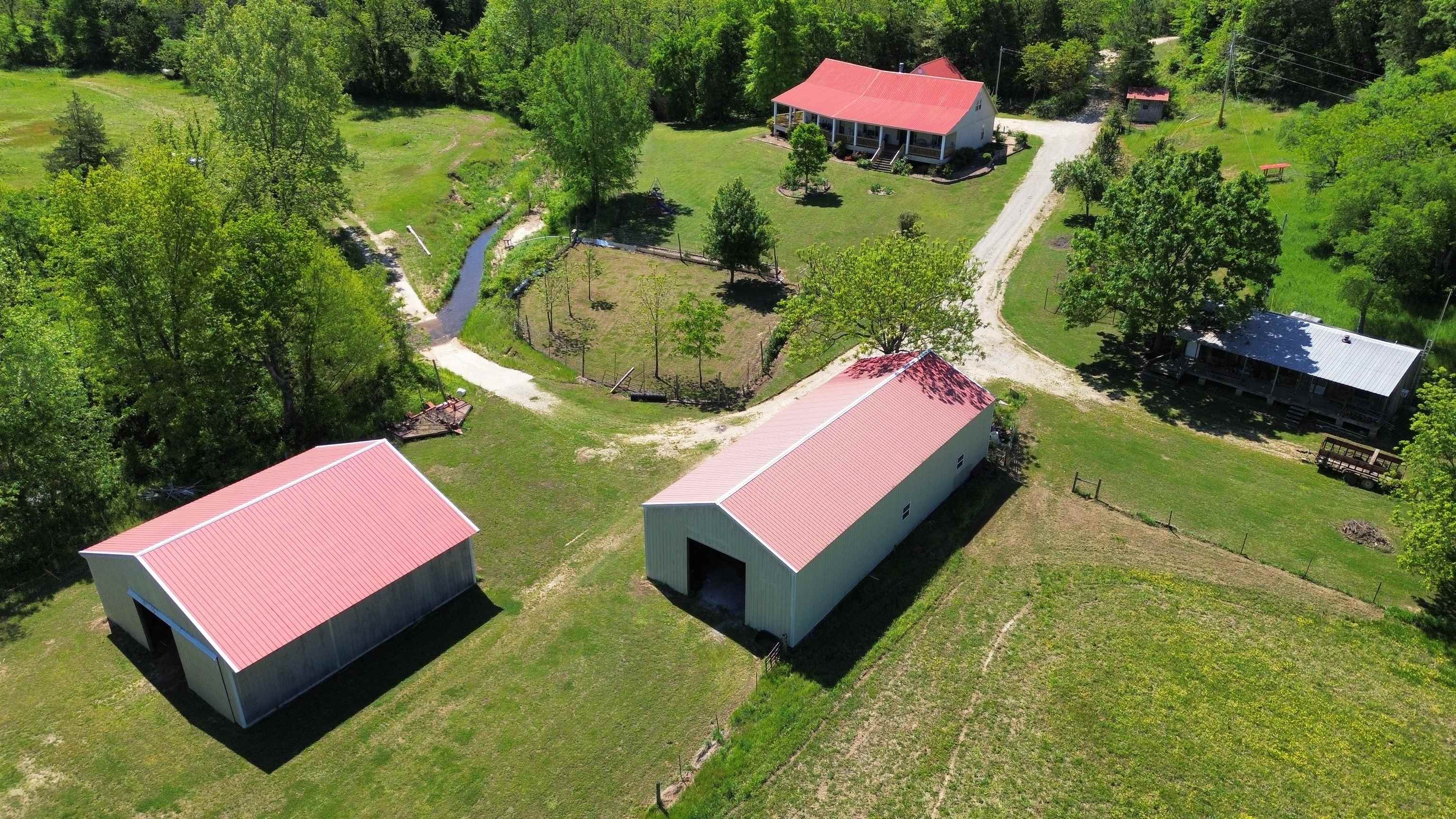 This is a prime 220 +/- acre hunting and recreational property with a true self-sufficient homestead, featuring a spring creekāirrigated garden that is surrounded by a fruit orchard of apples, peaches, blackberries, and muscadines. Approximately 5,000 feet of South Indian Creek runs through the middle of the property. The home features 4 bedroomsā3 on the main level and 1 upstairs as a bonus room. Thereās a large country kitchen and a great room centered around a massive stone, wood-burning fireplace. There is also a guest cabin, located within walking distance of the main house, that comfortably sleeps six. One of the best features of the home is the wrap-around front porch overlooking the creeks and garden, where you can often see wildlife right from your seat. This is truly a turkey hunterās paradise. There are two large metal buildingsāone is a shop with a big electric overhead door, and the other has 4 horse stalls with overhead hay storage. The property includes numerous small food plots and about 60 acres of creek bottoms that can be used for hay or larger food plots. With 2 year-round creeks and 2 year-round springs, thereās all the water you could ask forā $1,200,000.