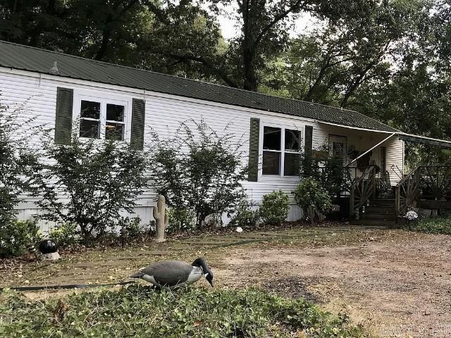 This mobile home sits on a very quiet and shady lot. It's been completely remodeled over time with custom wooden decks. It has a fully furnished guest house / mancave that is completely self-contained. It is attached with a large wooden deck perfect for sitting! This property also come with a 24' x 48' shop and a 24' x 48' shed that is perfect for RV storage. This property is a must see!