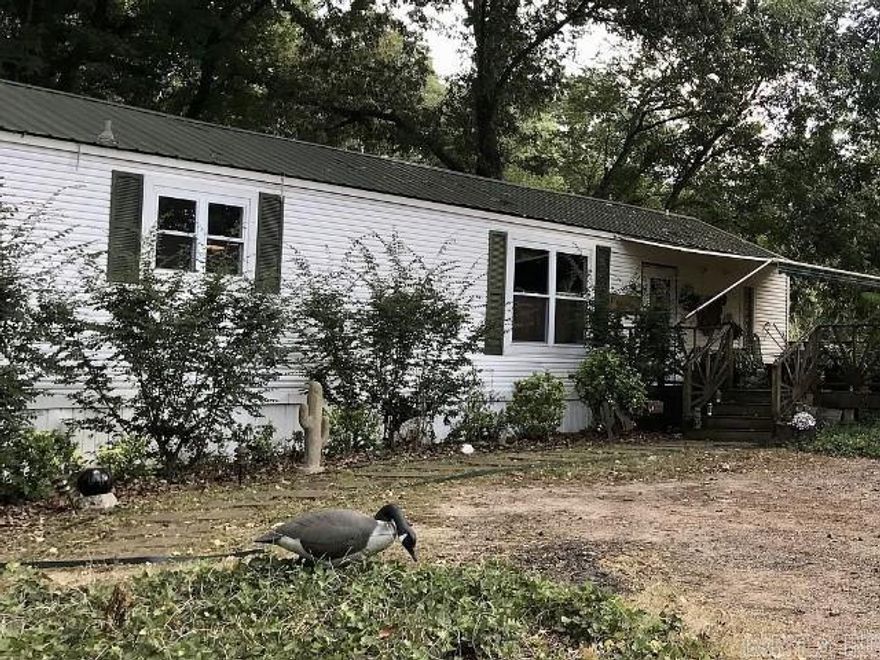 This mobile home sits on a very quiet and shady lot.  It's been completely remodeled over time with custom wooden decks.  It has a fully furnished guest house / mancave that is completely self-contained. It is attached with a large wooden deck perfect for sitting! This property also come with a 24' x 48' shop and a 24' x 48' shed that is perfect for RV storage. This property is a must see!