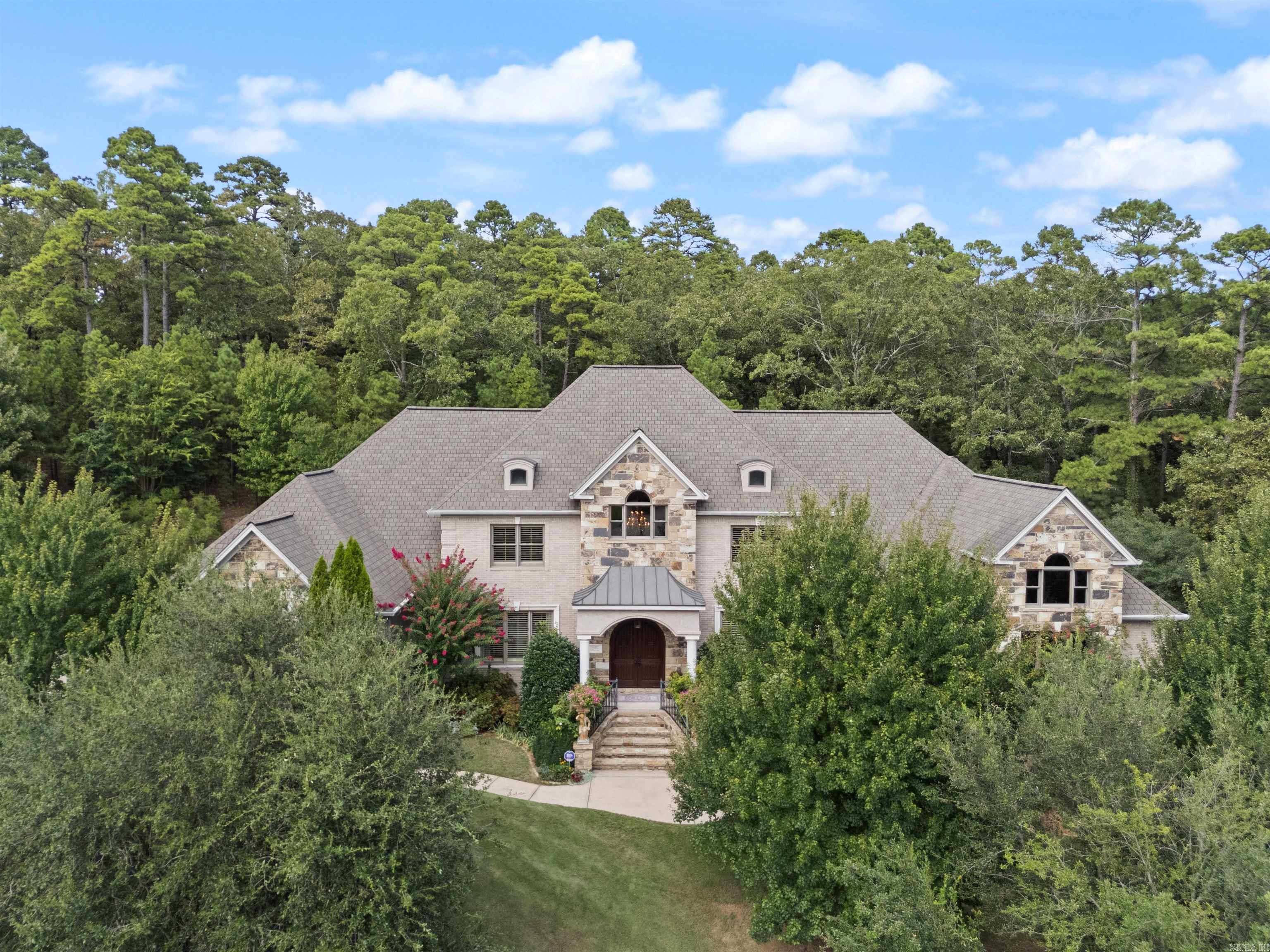 Welcome to this spectacular family estate nestled on 3.33 acres in a private, gated community along the scenic Arkansas River. This custom-built home boasts timeless architecture and high-end finishes throughout. As you enter the two-story foyer, complete with a stunning barrel ceiling, you will be drawn into the elegance of the formal dining room. The gourmet kitchen, designed with the discerning chef in mind, features top-tier Electrolux appliances, including a range with a pot filler, double ovens, warmining drawer, ice machine, & more. Just off the kitchen, a large patio and screened-in porch expand your entertaining space outdoors. Primary bedroom suite on the main level and upstairs. An additional guest bedroom is on the main level (used as an office). Indoor gunite pool with a Badu system for swimming or therapy, dry or wet sauna and wet bar plus a special heating and air conditioning/dehumdification system. Additional amenities include an elevator, game room, impressive theater, exercise room, generator and four car garage! Beautifully landscaped backyard features a cozy screened-in porch, patio and terrace offering both covered and uncovered spaces to enjoy the outdoors!