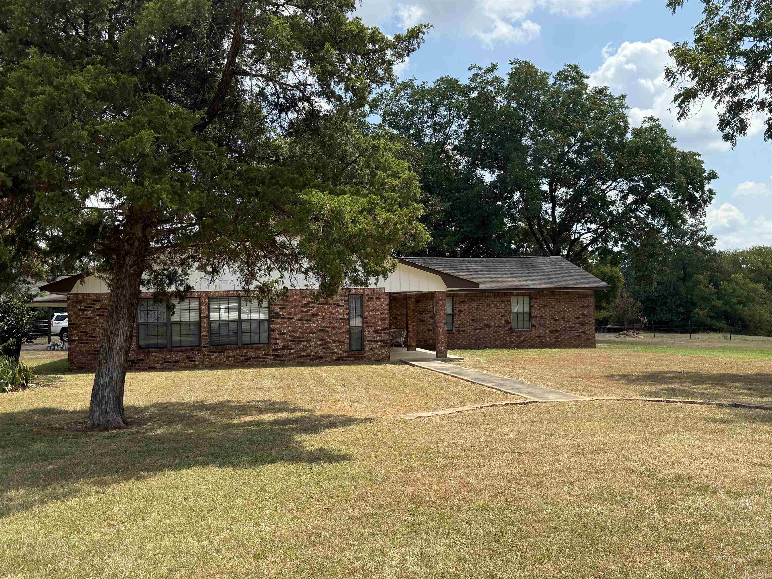 Large home west of Nashville, situated on approx 4.75 acres. Property offers a brick home with approx 2,635 sq ft of living space, 40x40 shop building with roll up doors, concrete floor, electricity, feed/hay room and two horse stalls. Home has 4 bedrooms and 2 fulls baths, kitchen with large dining area, family room with wood burning stove, spacious master bedroom offers built-in dresser/wardrobe, walk in closet, master bath with double vanity, walk-in shower and extra storage. Large laundry, double garage, 2 hot water heaters, one gas/one electric, CH/CA, storage building and patio. Contact our office for more details.