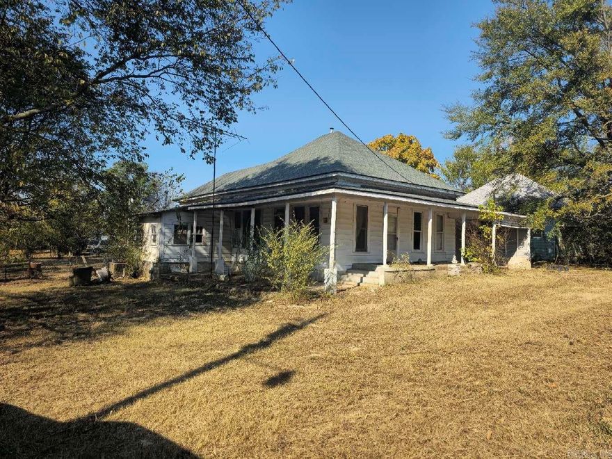 Large 3/2 with 3 lots. Remodel, restore, relax on the wrap around porch. There is space for 2 full baths. Living room, dining room, kitchen, and a bedroom have 10 ft ceilings. Carport has been enclosed, and could easily be converted back. Huge yard is mostly fenced. Year built is unknown, entered year is an estimate only.