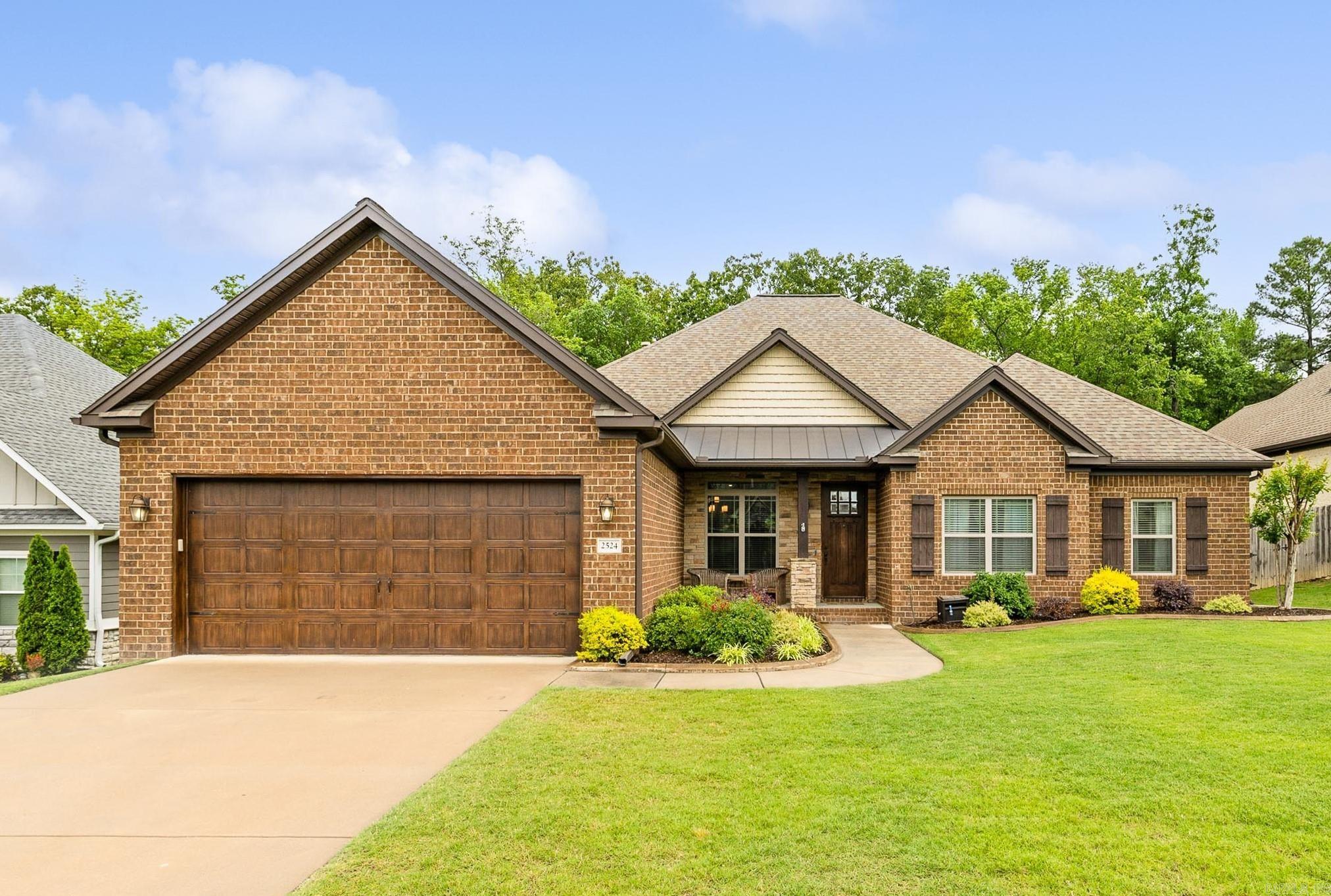 PRISTINE HOME IN THE HIGHLY SOUGHT AFTER HARPER'S LANDING NEIGHBORHOOD OF BRYANT! This stunning home features hardwood floors, soaring ceilings, and beautiful custom trim throughout. The chefās kitchen includes granite countertops, an island with gas range, spacious walk-in pantry, and wraparound bar seating that opens to a cozy hearth room with gas fireplace. A spacious living room and formal dining area make entertaining easy. The primary suite offers two vanities, two closets, and a custom tile shower, while the three guest bedrooms all include massive walk-in closets. Large laundry room with storage and mud area with bench and hooks. Situated on a large lot backing to private woods, the backyard features a covered porch, stained concrete patio perfect for a firepit, and a custom-built storage building on slab. Quiet, one-way-in, one-way-out neighborhood in the heart of Bryantādonāt miss this one!
