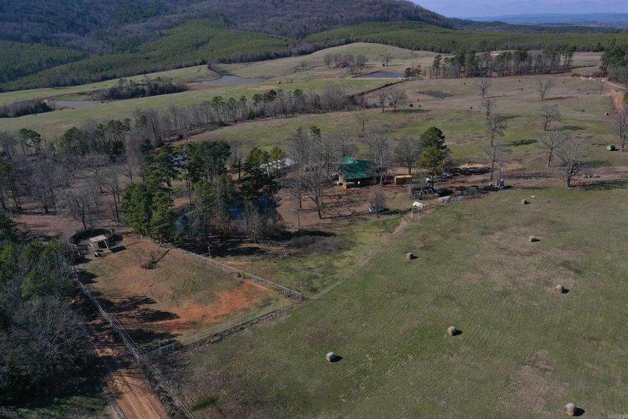 Properties with improvements centered around horses and the western lifestyle are few and far between. This 46 +/- Acre homestead is just that, with finishes and features the complement the western way of life. The just-over 1900 square foot two story log home has enough room for the whole family, with five bedrooms and two baths. The vaulted ceiling in the living room perfectly complements the stone fireplace, as well as the loft that accesses the two upstairs bedrooms. Covered porches and a sunroom make for the perfect spaces to enjoy time with friends and family outside. The 46 +/- Acres is a mixture of pasture and timber, with rolling topography and three ponds. Fenced and cross fenced pasture perfectly tie in to the horse barn and pipe arena. The seven stall horse barn has hay mangers and easy access doors, as well as a finished tack room, along with water and power. A fenced alley leads from the horse barn to the arena and round pen. The pipe arena is approximately 75x150, has lights, head and heel boxes and a roping chute. Behind the arena, a 40-foot pipe and wood round pen is tied in perfectly. Call today for your personal tour!