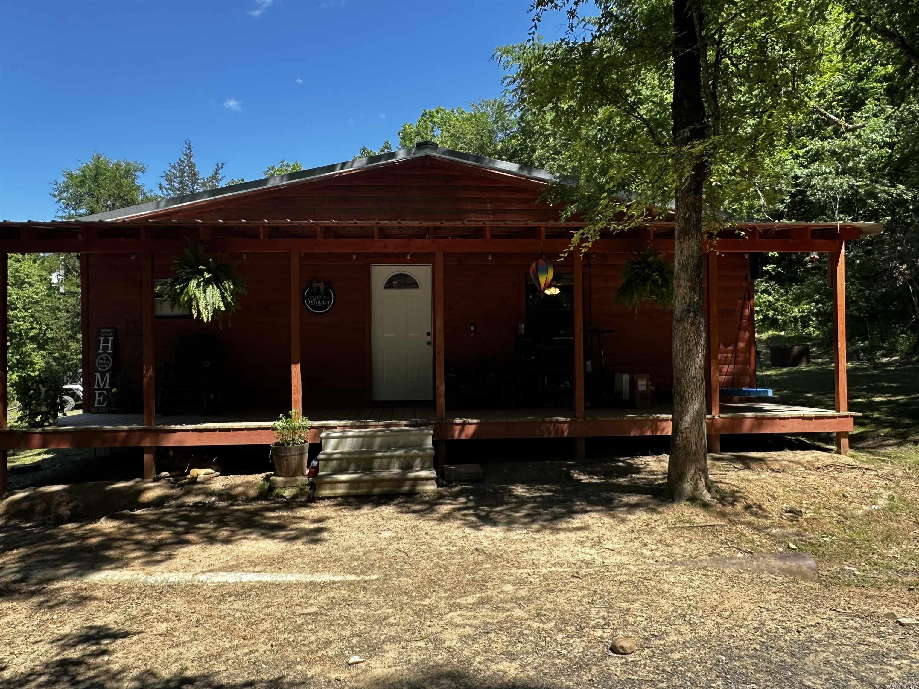 Nestled on a 20-acre wooded lot, this rustic 2-bedroom, 1-bathroom house offers a serene escape from the hustle and bustle of everyday life. If you’re seeking tranquility, privacy, and the beauty of nature, look no further—this property has everything you need. Just 5.5 miles from the shimmering waters of DeQueen Lake, you can easily indulge in a variety of outdoor activities—from fishing and kayaking to picnicking on the shore or hiking the surrounding trails. The property boasts a large garden area, perfect for the aspiring gardener and harvesting your own fresh vegetables. Step inside to find a cozy yet inviting interior. The open layout seamlessly connects the living and dining areas, creating a warm atmosphere perfect for family gatherings. Some appliances stay with the home along with the metal carport in the back. You are only 3.5 miles to the new Sevier County Medical Center, 9.5 miles to DeQueen, and 41 miles to Hochatown/Broken Bow Lake!