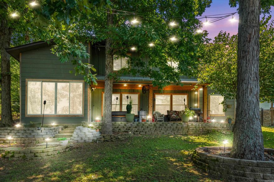 Imagine chilling by the water's edge nestled amidst the trees overlooking gorgeous Lake Hamilton.  This cozy home exudes warmth and relaxation from the moment you step inside. The interior design features a rustic elegance, with hardwood floors and exposed wooden beams on the ceiling. The soft earth-toned areas of the home create distinct living zones within the space while large windows across the back of the home allow natural light offering breathtaking views.  A short stroll down the gently sloping backyard leads to the lakefront and your private covered boat dock.  Lakefront living at its finest.