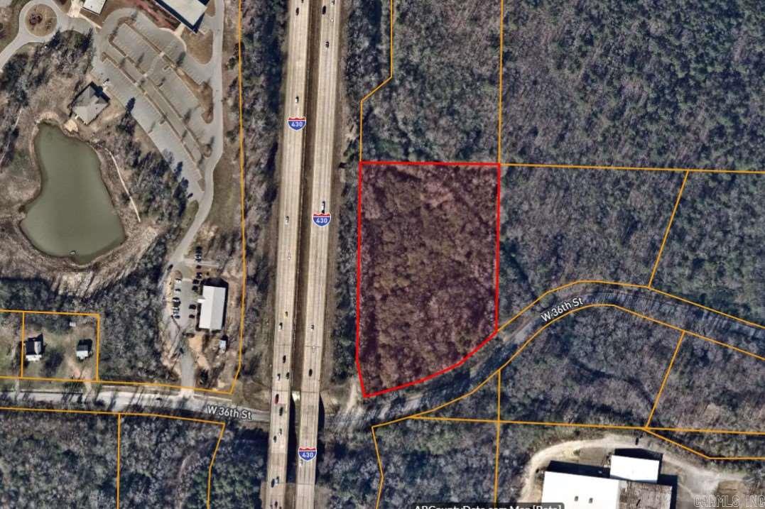 Wooded, level acreage with frontage on I-430 and 36th Street access. Great location with possible commercial use or multi-family housing.