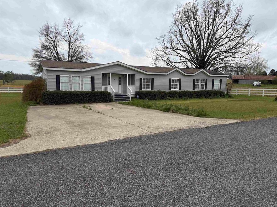 Country living at it's best. This beautiful 2560 sq ft doublewide mobile home is a must see. The home sit on 0.52 acres just outside Quitman AR, with a wonderful setting, a white vinyl fence surrounds the property on three sides, large shade trees make the perfect place to sit in the summer time in a nicely landscaped yard. The home comes with a woodburning fireplace with electric logs in place, a very large kitchen, living room and master suite. The home offers large windows for natural light ,  plantation shutters on the inside along with the heavy duty blinds. There is Carpet through out the home, all stainless appliances, large walk in closets . Greers Ferry lake is just a short distance away, along with the Little Red River. Conway is 30 minutes away for great shopping, Heber Springs for that downtown stroll .