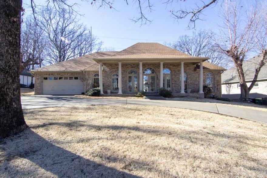 Custom Built Home - Indulge in Luxury living in this 3 Bedroom 2 1/2 bath home. Step in through the front door to inviting 12 foot ceilings throughout the living room and foyer. Formal Dining Room, Wood burning fireplace with gas logs present in living room. House has a huge primary bedroom with ensuite bathroom with marbled jacuzzi tub, double vanity with split bedroom plan. Huge walk in closet. Hardwood floors in kitchen and hallway. Office with built in shelving. Beautiful arched windows across the front architecture of this beautiful home with covered deck and brick flooring. French doors in the front, French doors out to the patio from the primary bedroom and French doors out to the patio from the kitchen. Kitchen is nicely laid out with tile countertops and walk in pantry. Has 8 foot privacy fenced backyard. Lot goes 35 feet behind rear fence for gardening. Heat and Air replaced in 2014, circular driveway, and 2 car garage with floored attic over garage for storage. Washer and Dryer convey.