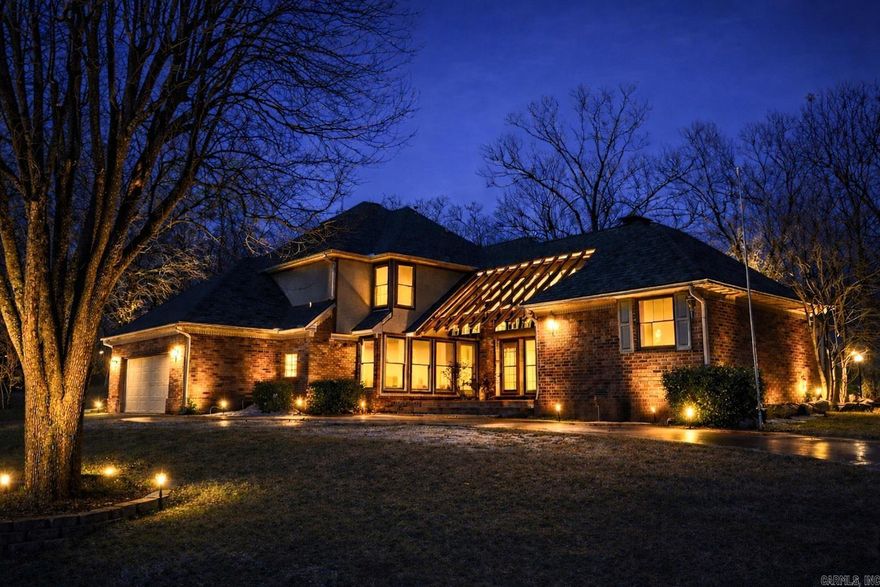 Rare lakefront estate on Lake Hamilton featuring 3.83+/- gated acres and over 500 feet of main-channel shoreline in Hot Springs. Properties offering this level of acreage, frontage, and privacy are increasingly hard to find.  The two-story home is designed for comfortable living and entertaining, with a main-level primary suite and ensuite bath, plus three additional bedrooms and a full bath upstairs. The layout provides ideal space for guests or multi-generational living.  Warm, inviting living areas with fireplace capture lake and mountain views. Outdoor living is enhanced by a stone and brick patio at the water’s edge. Mature landscaping, waterfall feature, and lake-fed irrigation system add to the setting. Private boathouse with lift offers direct main-channel access.   Additional features include a two-car attached garage and three-car detached garage for ample storage. A rare opportunity to own a premier main-channel lake property with space, privacy, and extensive frontage.