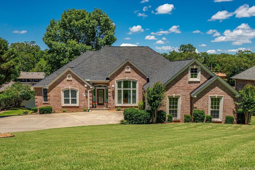 Welcome to this stately brick home, perfectly positioned on 117’ of Lake Hamilton frontage. Built by Carriage Custom Homes, this property is now for sale for the first time. Enjoy a 2-stall covered boat dock with lifts, lush landscaping, peaceful patios + decks, and colorful sunrise views.  The main level centers around a warm living room, formal dining space, dedicated office, and spacious eat-in kitchen. Also on the walk-in level are the primary suite--with a beautifully appointed bath--two guest bedrooms, guest bath, and a laundry room conveniently located near the 2-car garage. Downstairs opens up to a generous entertainment space with two additional bedrooms and a full bath. Most every window offers a serene water view. Recent updates include energy-efficient windows, 95% high-efficiency gas heating systems, new roof, new solid oak hardwood flooring, and an upgraded primary bath. Stonegate Shores offers premier amenities, including a pool, clubhouse, tennis and basketball courts, plus RV and boat trailer parking—all for an annual POA fee of just $780.
