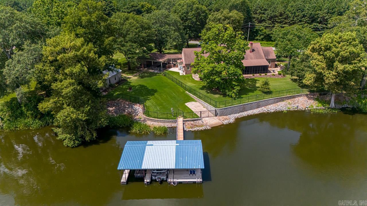 Experience lakeside luxury in this stunning 4,109 sq. ft. home on Old River Scott. This elegant residence features 3 bedrooms, each with a private bathrooms. The master and one of the en-suite bedrooms offer picturesque views of the lake. The large open kitchen, breakfast nook, and living room—all designed to highlight the serene lakefront setting. All kitchen appliances convey! When walking around the property you will find multiple outdoor spaces that are perfect for entertaining. Lawn and garden irrigation utilizes lake water and an automatic insect treatment system make these spaces enjoyable year around. Enjoy Old River lake access with a private concrete boat ramp and an expansive dock, ideal for boating and fishing. Catch limits of crappie right off the dock! The boat dock includes two boat lifts. Nestled in tranquility yet conveniently close to Little Rock, this home blends peace and accessibility perfectly.