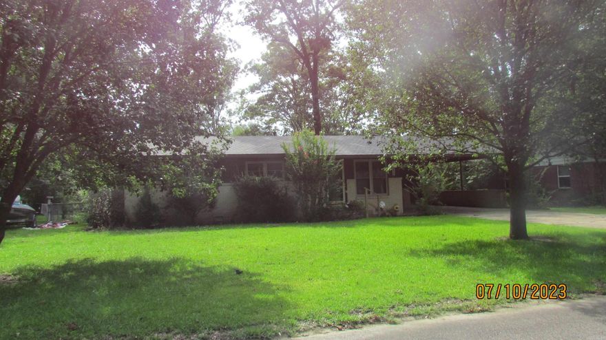 This lovely home features a formal living/dining room and a large den with a fireplace. (heater is in fireplace now hooked to gas making it easy to install gas logs) with vinyl flooring, a breakfast eating area,  kitchen with refrigerator and stove. Home also features three bedrooms, a hall bath with new walk-in shower, and a half bath.  Home has central heat and air, , laundry room in storage room off double carport, another storage room off carport, large fenced in yard with a large shop.