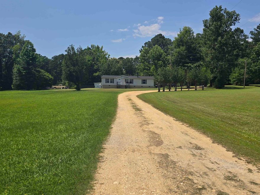 This charming home sits on approximately 4.95 acres with a pond. Is located out of city limits but only 15-20 minutes away from shopping. Updates done to the home: 2019 new deck out front, 2021 carport was added, 2022 new under pining and releveled, 2023 new 4 ton heat pump, 2024 new roof. Kitchen appliances stay. Washer, dryer, and deep freezer will not convey. There is a 30x50 slab for a shop and a storage shed.    Agents please see remarks