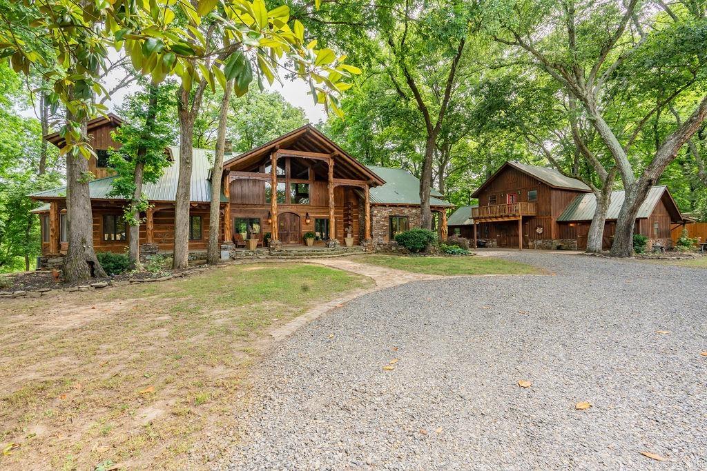 This magnificent, custom built log home is constructed with all of the finest expertise. Enter into the impressive living area with a massive fireplace to be greeted by the beautiful views of the river. This 5 bed, 3.5 bath home has multiple options for additional sleeping arrangements, dedicated office space, primary w/ensuite and loft area overlooking the river, and a guest bedroom with ensuite on the main level. Upstairs offers another loft area suitable for a bedroom and/or gameroom. The chef's kitchen features commercial grade Viking and SubZero appliances and granite countertops. Downstairs you will find another spacious living area, kitchenette with laundry, 2 guests bedrooms and bath, a full bar for entertaining and wine cellar with a table for those special wine tastings or a game of poker. The impressive front porch with lodge style log beams catch your eye as you pull into the circular drive. Off of the sunroom a peaceful escape on the covered porch overlooking the river awaits. Easy access to the private dock with boat slip and sitting area for fishing. The shop is ready to house whatever hobby suits and the apartment upstairs offers additional living space. Must See!