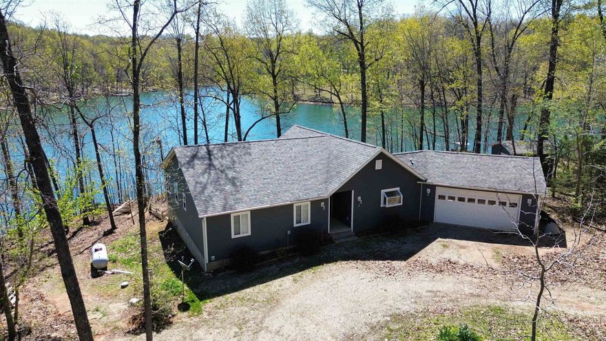 Experience Lake Aztec living in this stunning 3 bed 2 bath 1,800 sq ft home built in 2018, perfectly situated on 1 acre with an impressive 450 feet of waterfront. Located in a quiet neighborhood and surrounded by mature trees, this property offers breathtaking water views and a peaceful setting. Inside, the open-concept design features vaulted ceilings, abundant natural light, and a beautiful gas log fireplace. The custom kitchen is a standout with gorgeous cabinetry, granite countertops, and a gas stovetop—perfect for both everyday living and entertaining. The primary suite offers a private retreat with a large walk-in closet and a spa-like bathroom featuring double vanities, a jacuzzi tub, and a walk-in shower with lakeviews. Step outside to the expansive deck overlooking the water—ideal for relaxing or hosting guests. Brand new dock and fenced in backyard. Complete with a two-car garage and additional storage building, this property blends comfort, function, and lifestyle. Don’t forget you also have fiber optic Internet!