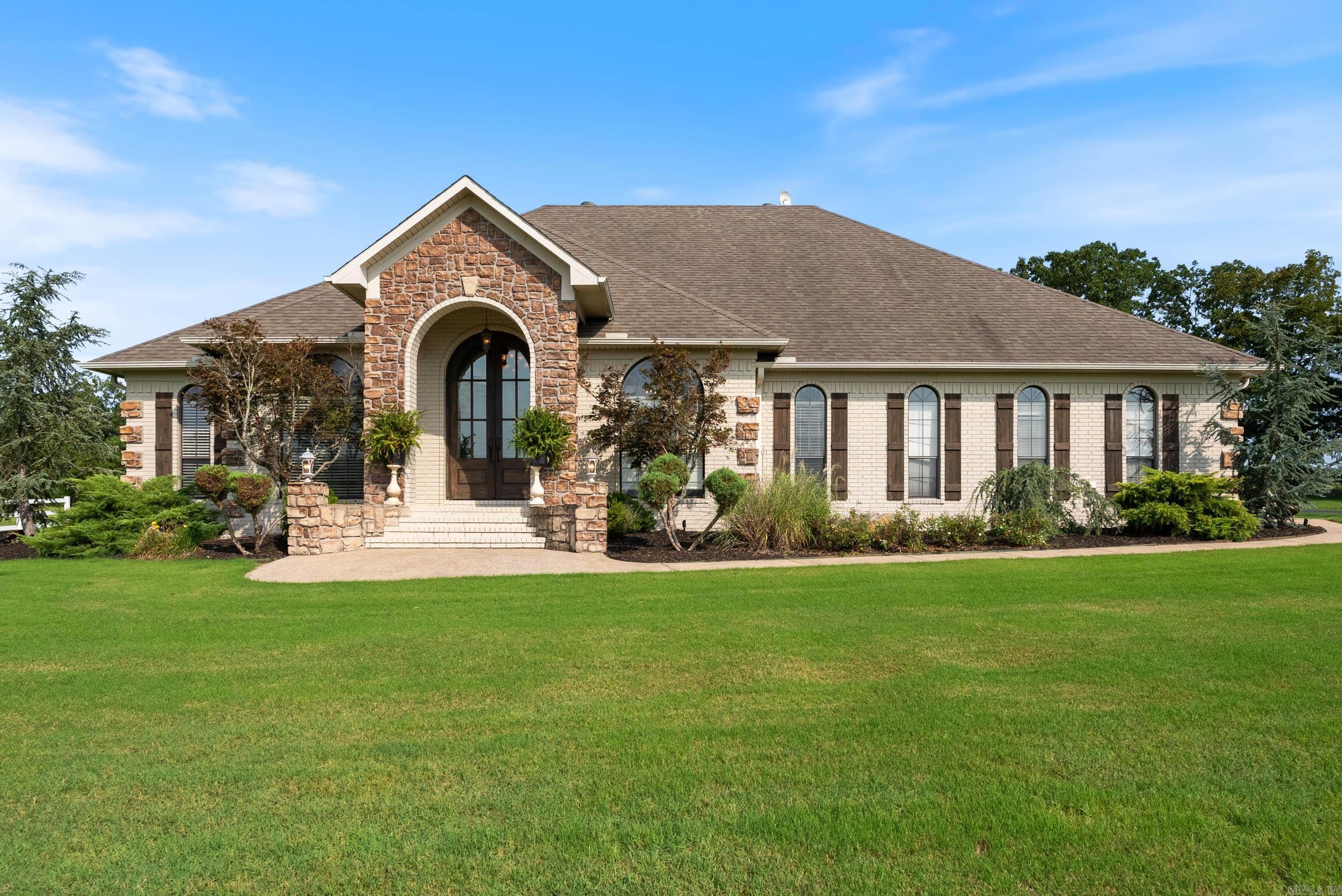 Seller offering 10,000 towards closing costs or rate buydown w/accepted offer! Situated on 3.93 acres, this stunning residence offers luxury & privacy. This one of a kind property has it all with no restrictions. Boasting 4BR/2.5BA, & 2,813 sqft, this home is the perfect place to call your own. The property welcomes you w/ a beautiful white vinyl fence, fully paved driveway, & extensive lush landscaping. The grand entry features gorgeous rock detail, stunning 11 ft arched mahogany doors & beautiful arched windows w/custom plantation shutters. Step inside to 12 ft ceilings & custom french country built-in entertainment center. Cozy up by the wood burning fireplace that is conveniently vented to warm bedrooms. The kitchen features granite countertops & stainless steel appliances. Enjoy evenings on the spacious covered back porch. The 2-bay 30x40 shop w/ a 1000 sqft lean-too is perfect for all your hobbies, projects & extra storage. The home acquires an in ground tornado shelter & extra storage/cabinet space in the garage & an in ground sprinkler system. Secluded, yet accessible, this home is located in top rated Greenbrier School District.