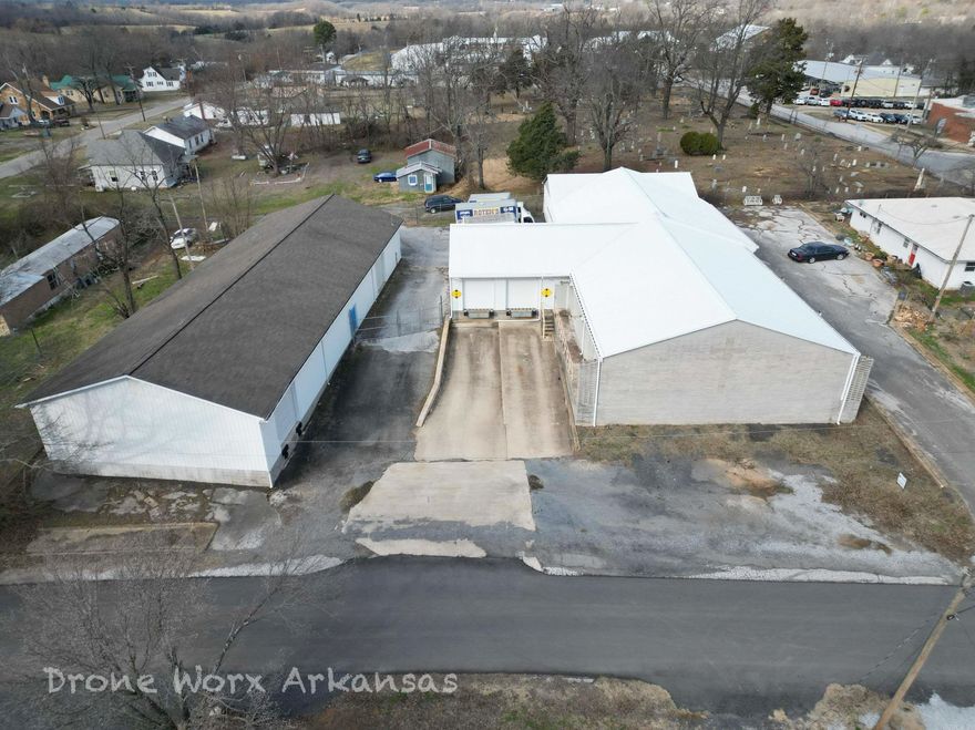 Two warehouses on one lot with fencing, loading docks, roll up doors and plenty of parking. Office space or workshop rooms are located within.  These buildings would  make a great location for any manufacturing, storage, shipping, and more. With metal and brick exteriors, they are virtually maintenance free.  There are enough exterior access points for client/customer interactions, as well as large access doors for moving large items in an and out whether for sales, delivery, or repair.  This property is just a short walk to the downtown square of Marshall, AR where much of the commerce is had in this hometown feel community.