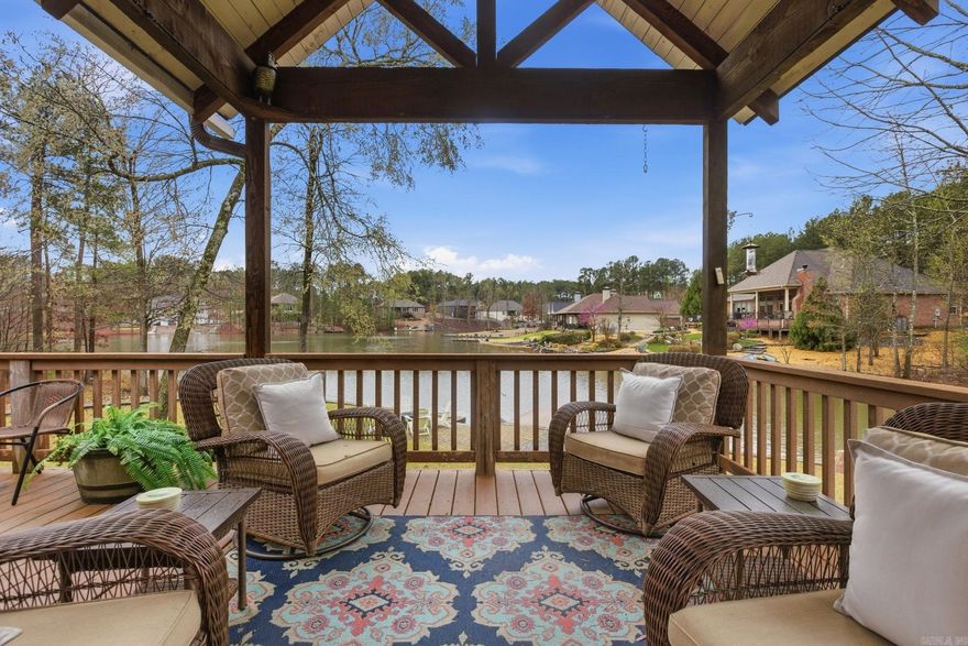 Enjoy the best of lakefront living at 17 Vista Ln. in Hot Springs Village. Situated on Lake Estrella near the #2 green of Granada Golf Course, this beautifully maintained one-level home offers breathtaking water views from soaring vaulted ceilings and walls of windows filled with natural light. The open-concept floor plan is designed for entertaining and everyday comfort, featuring hardwood floors, a stone fireplace, and seamless access to a spacious covered Trex deck overlooking the lake. Outside, 160 feet of seawall frontage, steps to the water, and a swim dock for kayaking, fishing, swimming, or relaxing lakeside evenings. The split-bedroom layout provides privacy, with a Jack-and-Jill guest wing and a spacious primary suite showcasing peaceful lake views. A separate 400 sq. ft. bonus room with full bath (excluded from the main sq footage) offers endless flexibility as a home office, guest suite, craft room, media room, or home gym. Additional upgrades include an oversized 3-car garage, and an encapsulated crawlspace. At the end of a cul-de-sac this rare waterfront property combines privacy, panoramic lake views, golf course scenery, and exceptional indoor and outdoor living.