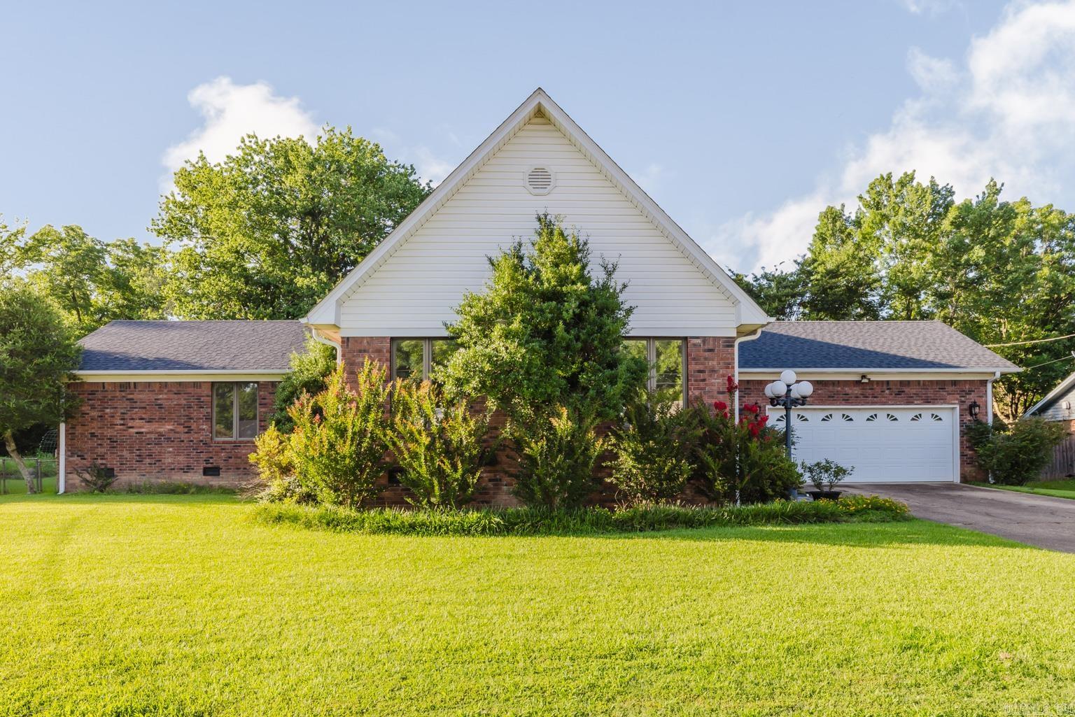 A dream home in downtown Benton built by the esteemed JB Ballard! Just a short walk to all the charming shops downtown, this spacious property is nestled in a quiet neighborhood, yet close to the heart of the town. The huge primary bedroom is separate from the guest bedrooms, which share a Jack-and-Jill bathroom. Closet space galore! Separate laundry room! The open kitchen flows seamlessly into the living room, making it easy to host guests. The gas logs in living room are original gas logs from the Gann House. The fully finished basement is complete with a fireplace, wet bar and full bath- perfect for extra living space or office. The covered porch is an ideal spot for entertaining or enjoying a peaceful morning coffee. With a new roof in 2024 and a sprinkler system to maintain the lush landscaping, this home is a must-see! *Square footage upstairs is 3130 and downstairs is 1149*
