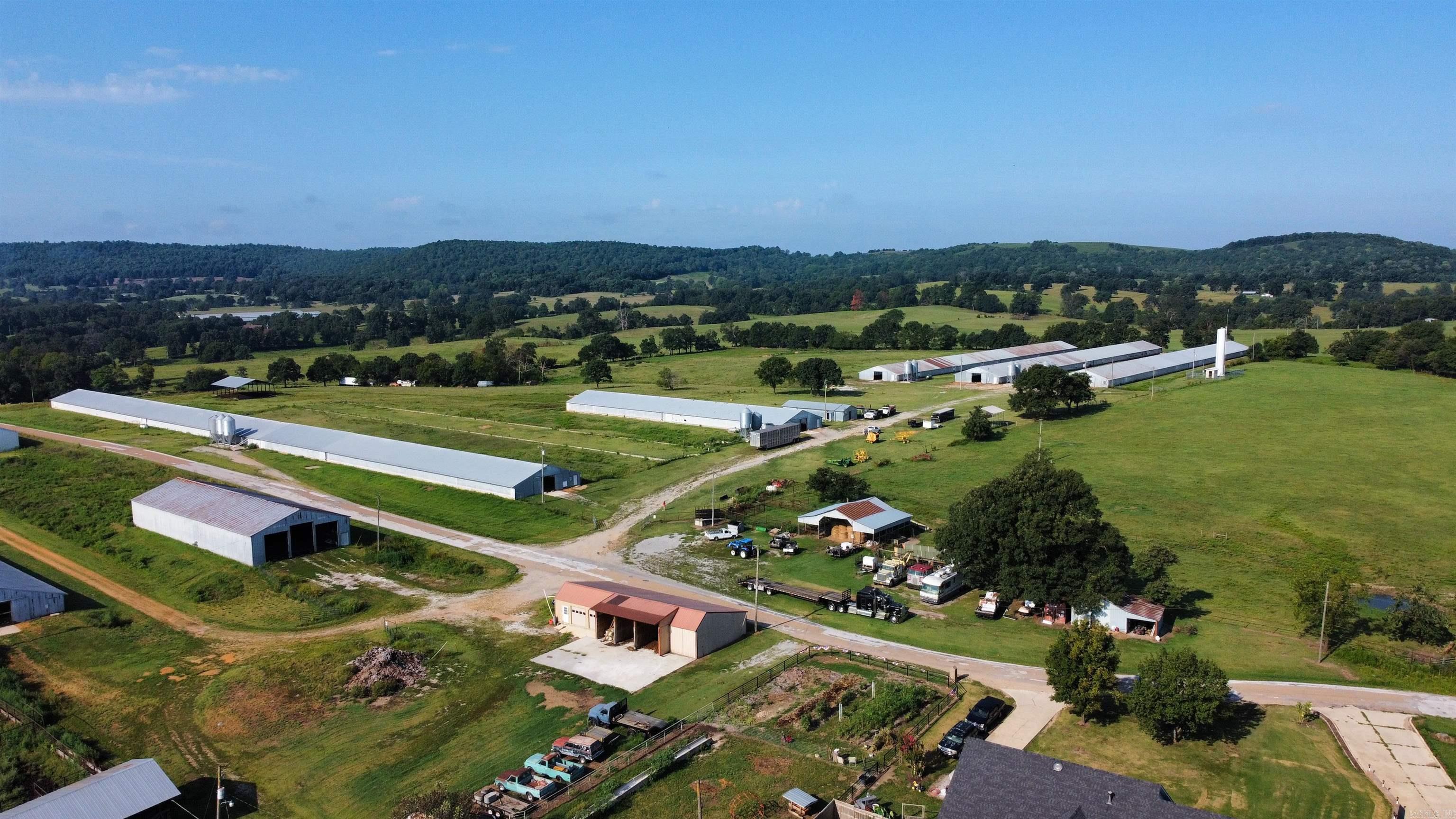 Marion county farm previously ran as a turkey farm could be updated to still run turkeys or chickens. Five barns totaling 120,000 sq ft sitting on 30 pasture acres with a pond all fenced and cross fenced. There is one 720x50 footing that could have another barn. Workshop with 3 phase power and bathroom along with 5 - 1000 gallon water tanks. Both city water and a well (40 gpm). Houses are heated with propane. Hook ups for a home or trailer as a residence on site. Separate carport for equipment and a large stacking shed for hay or other storage.