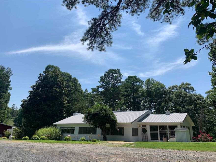 This one of a kind property is located in appropriately named Cozahome in the beautiful Ozarks near the Buffalo National River with an abundance of wildlife. These 20 mostly wooded private acres have been home to the same family for the past 55 yrs! The center of the over 3000 sq ft charming farmhouse is a vintage log cabin. Special features include a wood burning fireplace, wood beams, wood ceilings, a large glass sunroom/den, beautiful ensuite master bathroom with jetted tub, breakfast bar, 2 kitchen stoves, a 800 sq ft unfinished basement/saferoom/root cellar, & enclosed porch across the entire front of the home perfect for an office, addtl bedrooms, guest sleeping quarters, sewing room, or a breakfast nook! The 30x38 pole barn, 24X34 barn with 10X34 lean-to, & 12X24 shed make this the perfect place to house a horse, farm animals, or store farm equipment or ATV's. Private well. Septic. Internet. Areas for gardens. Perfect area for setting up RV rental sites too! Nice place!