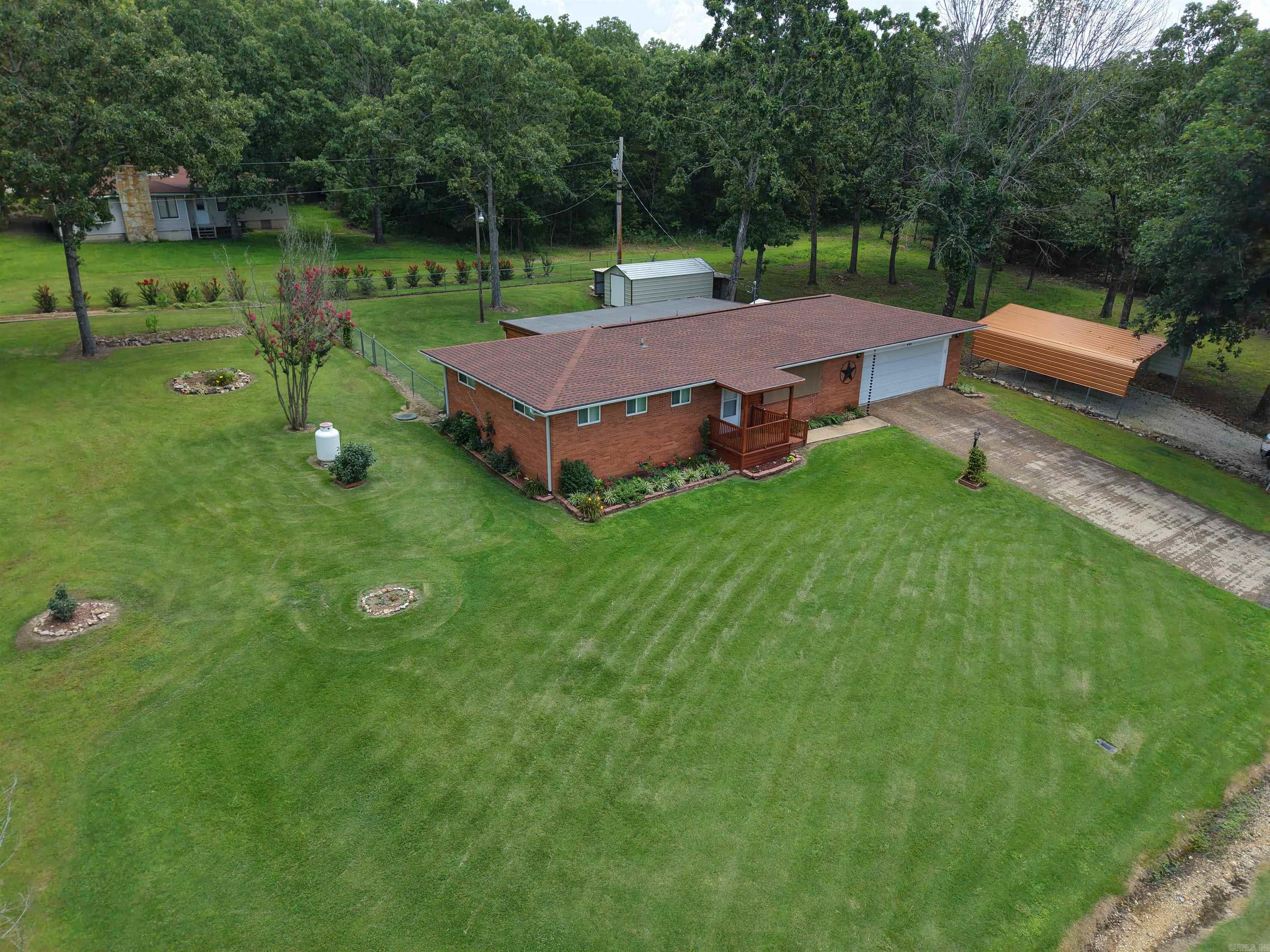 This meticulously maintained and beautifully renovated 2-bedroom, 1.5-bathroom home sits on three spacious lots in the Sequoia subdivision of Horseshoe Bend, Arkansas, offering plenty of room to relax, garden, and enjoy the outdoors. Recent upgrades include a new roof and remodeled bathrooms, ensuring modern comfort and peace of mind. Outdoors, you'll find a fully fenced backyard, vibrant rose bushes, mature landscaping, and multiple garden spots perfect for green thumbs. A detached carport, large 2-car garage, storage building, and workshop provide all the space you need for vehicles, tools, and hobbies. Unwind in the inviting cedar sunroom, complete with a mini-split system, ceiling fans, and a flat-screen TVāthe perfect spot to enjoy your morning coffee or evening relaxation. This move-in ready home offers the ideal blend of modern updates, outdoor space, and functional extrasāall for just $179,900!