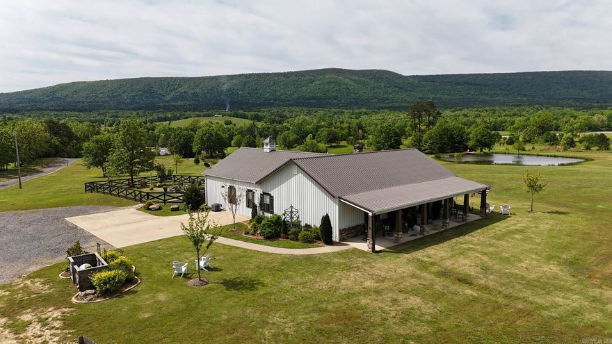 3-bedroom, 3-bath custom home of approximately 2,568 square feet by Dennis Salisbury Construction, designed in a barndominium-influenced style on about 28.88 acres with mountain views, a stocked pond, and a reported national forest boundary. The open main living area features a large window wall oriented to the views, fireplace, shiplap accents, vaulted ceilings, granite countertops throughout, and custom cabinetry. Each bedroom functions as a suite with its own bathroom, and the home also offers heated bathroom floors, a small loft office, extensive built-ins and storage, and a storm shelter within the primary bedroom closet. Exterior improvements include a 30' x 60' shop with 10-foot walls and a 12' x 60' lean-to, extra storage garage, greenhouse, inground pool, rock patio with fire pit, and an approximately 480 sq ft guest space above the shop that could be used for visitors or multi-generational living, subject to any local use requirements. The acreage provides additional mountain views, a stocked pond, tower blinds plus other stands, and mixed habitat that may support local wildlife; buyers should verify acreage, boundaries, pond stocking, and all improvements & intended uses