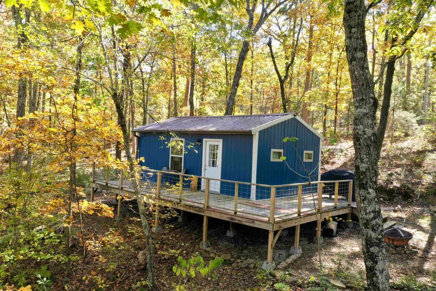 Looking for your own private hunting land and cabin, or just a getaway retreat in the woods? This property is a must see. Private drive into a beautifully wooded escape. Newly built cabin with metal siding for easy maintenance and a wrap around deck overlooking the sloped, wooded acreage. This studio cabin has enough space for a full size bunk and 2 sofas in the living area, spacious bathroom with a shower and a kitchenette for your convenience. 384 sq feet of heated and cooled space, 10 acres of privacy. Also offering a seasonal creek at the bottom of the hillside. Excellent hunting for deer and turkey, game camera pictures provided. There is an additional 5 acres adjoining that will be available to purchase, agents see remarks.