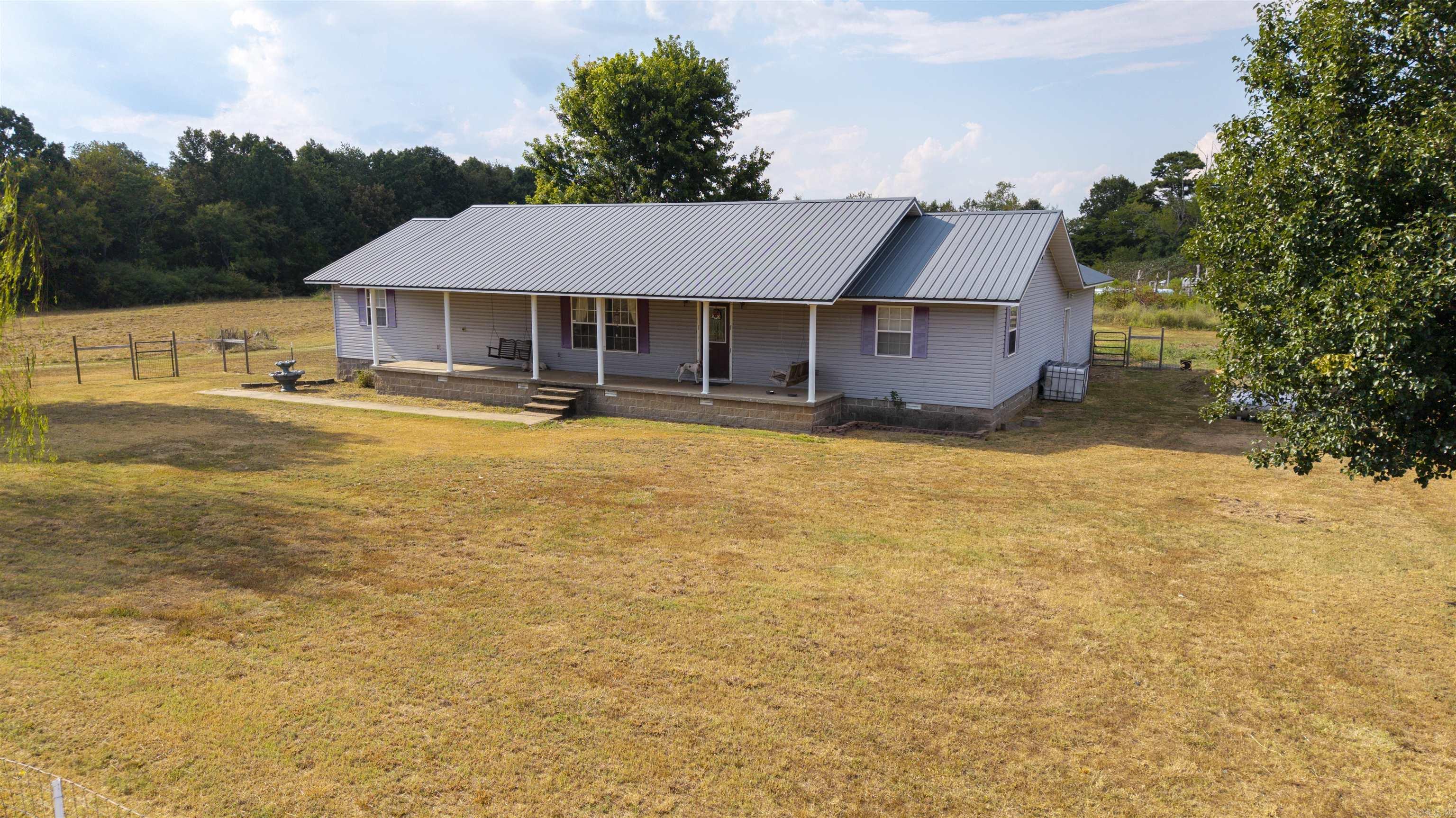 This spacious 3-bedroom, 2-bath home sits on 10 beautiful acres, offering privacy, comfort, and endless possibilities. The open floor plan creates a warm and inviting space with plenty of cabinet storage, while the kitchen comes fully equipped with all appliances included.The master suite is thoughtfully separated from the other bedrooms and features a large bathroom with a walk-in closet for added convenience.Step outside and youāll find a covered front porch perfect for watching the sunrise, a one-car garage with built-in shelving, and a tin roof built to last. The property is partially fenced around the home and fully fenced on three sidesāideal for pets, livestock, or future projects. A chicken house, the beginnings of a pole barn, and room to expand make this property ready for your vision.Nature lovers will enjoy deer right in the backyard as well as a wet-weather creek along the property edge. The land is level and mostly cleared, providing excellent space for gardening, recreation, or additional building.Located on a quiet dead-end road with only a couple of neighbors, youāll enjoy both seclusion and convenience. Schools, shops, and local amenities are close by.