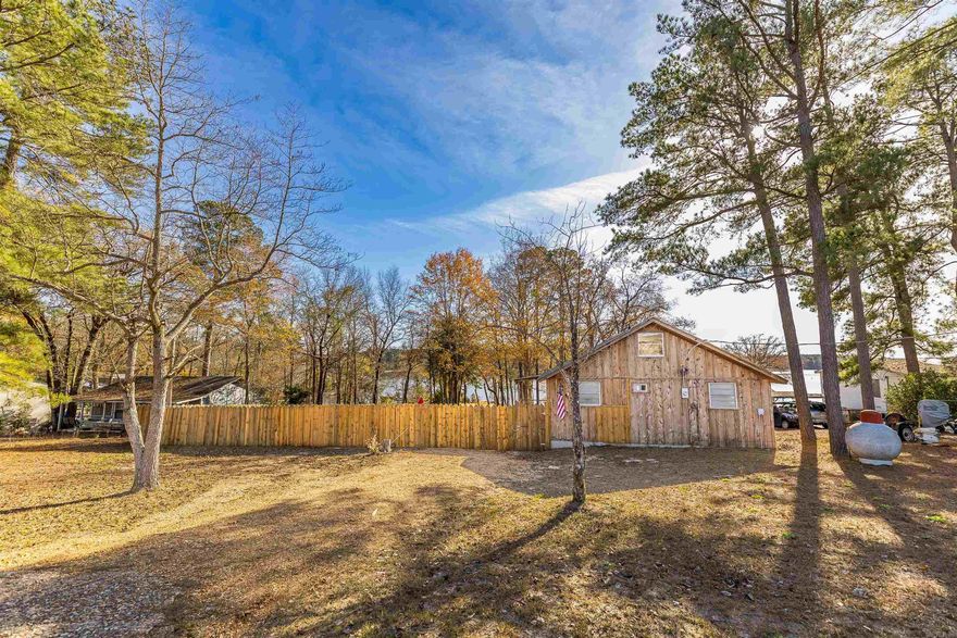 Charming cedar waterfront home! The high vaulted ceiling provides an airy feel with natural light providing a view of Upper White Oak Lake. Enjoy lake life from the back deck, or on the water from your own dock/boat shelter. The layout offers two downstairs bedrooms, and one loft bedroom. Newer metal roof and HVAC unit! Sitting on 1.5 lots, this property is a unique find!  Newer privacy fence to enhance the peace of living on the water.  For a video tour, search on YouTube using the listing address. **Buyers, please be aware that Arkansas Game & Fish have covenant restrictions governing the area.