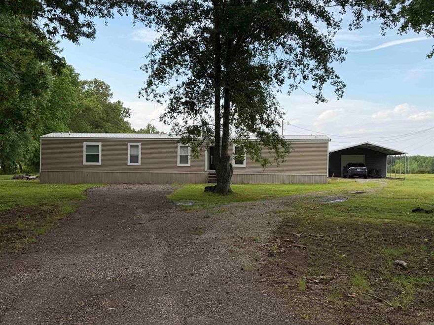 Welcome to peaceful country living with modern comfort! This like-new 2023 mobile home offers 1,216 sq ft of well-designed space on a beautiful 1-acre lot. Step inside to an inviting open layout featuring luxury vinyl flooring throughout the main living areas and carpeted bedrooms for added comfort.  The kitchen and living area flow seamlessly, perfect for everyday living or entertaining, with plenty of natural light creating a warm, welcoming feel.  Enjoy your morning coffee or unwind in the evenings on the 8’x10’ covered back deck, overlooking your spacious property.  Outside, you’ll find a paved driveway leading to a 24’x25’ shop—ideal for hobbies, storage, or workspace—plus an attached 20’x24’ carport providing ample covered parking.  If you’re looking for a move-in-ready home with modern finishes, functional outdoor space, and room to breathe, this one checks all the boxes!