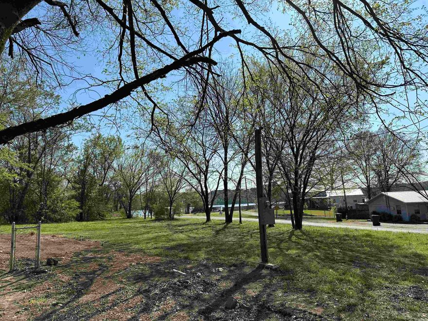 Just outside of city limits and across from Lake Catherine is this sweet level lot. Wooded tree line, lot line is inside the tree line on one side. Fresh survey markers are out. 2 Mobile home hook ups from trailers recently removed. City water and sewer are present. Entergy power pole on lot. Across the street from the floodplain, only the creek on the left side of the lot would require flood insurance. The Shop, trailer or home placement would not. Photo of lake is from the end of the street. A second story building would have a lake view. Wooden shed does not convey unless acceptable offer, seller in process of removing.