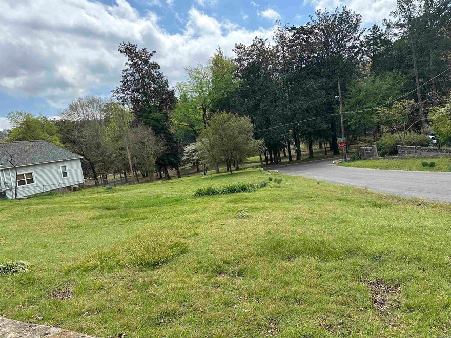 Just outside of city limits and across from Lake Catherine is this sweet level lot. Wooded tree line, lot line is inside the tree line on one side. Fresh survey markers are out. 2 Mobile home hook ups from trailers recently removed. City water and sewer are present. Entergy power pole on lot. Across the street from the floodplain, only the creek on the left side of the lot would require flood insurance. The Shop, trailer or home placement would not. Photo of lake is from the end of the street. A second story building would have a lake view. Wooden shed does not convey unless acceptable offer, seller in process of removing.