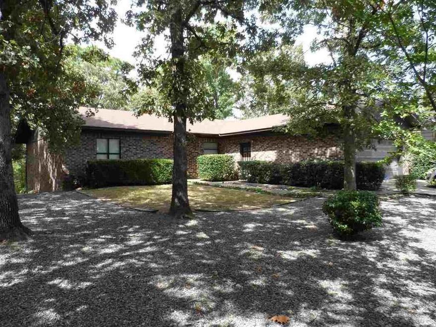 Lovely home sitting  on over 1/2 an acre across the street from Lake Hamilton with private lake access. Home boasts an open floor plan with winter lake views, screened in porch, updated kitchen, 2 fireplaces with one being wood burning and the other butane, split floor plan, new roof, 40x25 covered RV parking pad with 50 amp outlet and sewer line. Low maintenance brick home, extra storage under home, low maintenance yard. This is a must see!