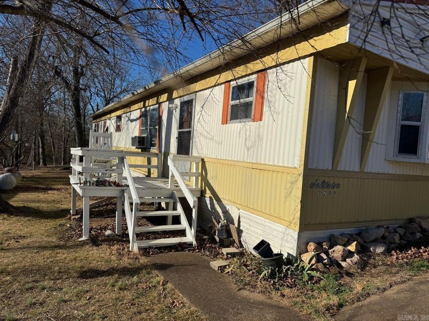 Experience park-like living in this well-maintained 2-bedroom, 2-bath manufactured home set on almost an acre. Step inside to a welcoming living room with brand-new flooring (and extra materials ready to complete the look). The home features a cozy wood stove for those cool evenings, along with a wall-mounted gas heater for reliable backup warmth. The spacious kitchen boasts new appliances, ample cabinetry, and a reverse osmosis water system for fresh, clean drinking water. You'll love the dedicated laundry area, thoughtfully designed for practicality, and the home's exceptionally low utility bills, thanks to energy-efficient systems. The property includes two outbuildings—ideal for storage, hobbies, or a workshop
