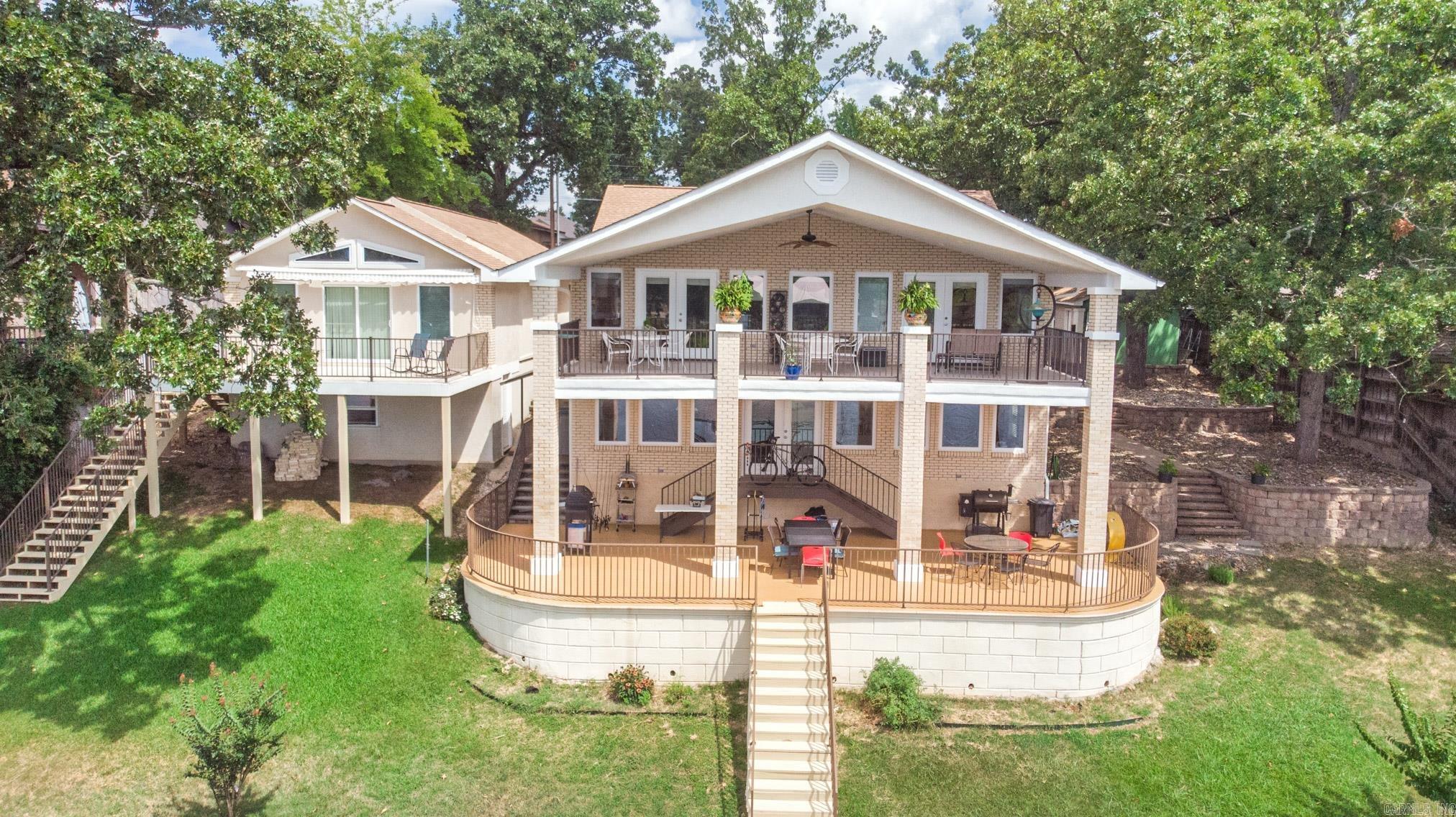 Cheers to enjoying beautiful Lake Hamilton from your waterfront compound located in the popular 7 South corridor! Upon entering the gated drive, you will recognize this unique property presents many opportunities. Main residence includes a 2/2 Main Level and 1/2 Lower Level with 2nd full kitchen and laundry. The coordinating guest house offers the same waterfront views and full service amenities including its own kitchen, laundry and entertaining space. Enjoy as a personal residence or prime investment.