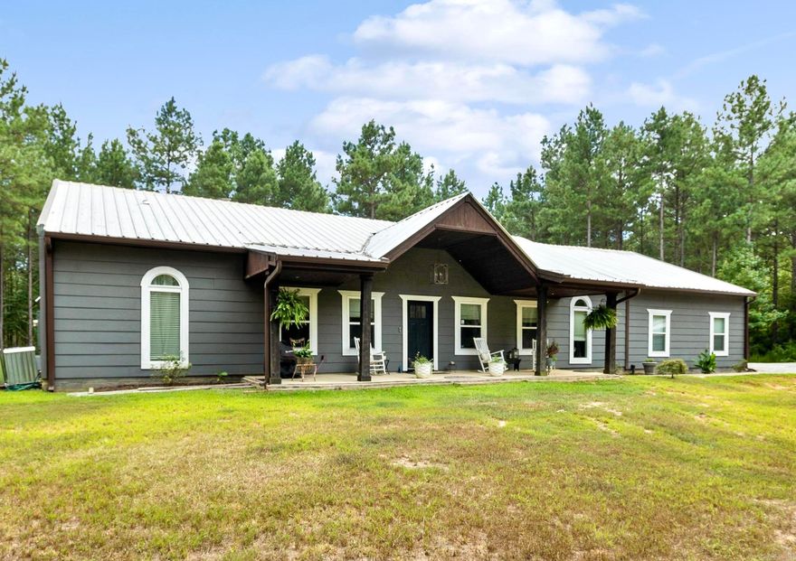 ONE LEVEL MODERN FARMHOUSE ON 10 ACRES PRICED 25K UNDER APPRAISAL!! This custom built home features an open kitchen with a gas range, large, walk-in pantry, dining area and island with a breakfast bar. The living room is very spacious and showcases wood detailing throughout. There are beautifully repurposed 100 year old antique doors with crystal knobs throughout the home. The primary suite also includes wood detail on the ceiling, a large custom tile walk-in shower, dual countertop sinks, and a walk-in closet that doubles as a safe room with concrete walls and a built in safe in the ground. Guest room includes a built-in Murphy bed and a walk-in closet. The two additional guest rooms feature en-suite bathrooms. There is a designated office near the kitchen along with a spacious laundry and mudroom. Three car garage, and one bay is being used as a shop and is insulated and cooled. There’s a very spacious backyard with a fence that would be perfect for a pool, and a shed perfect for storing outdoor equipment. The property is gated for extra safety and is just waiting on its perfect new owner! Agents see remarks.