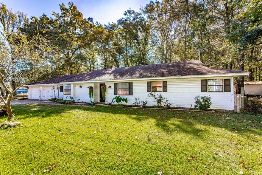 Discover country living at its finest in this 4-bedroom, 3-bath ranch-style home surrounded by 3.16 mostly wooded acres. Enjoy peace and privacy with livestock allowed, a huge fenced chicken coop area, and a 20x20 shop with electricity and RV hookups. Relax or entertain on the new covered deck and grilling area or the enclosed covered porch. Inside, the open floor plan features luxury vinyl plank flooring and warm knotty pine tongue-and-groove walls throughout. The spacious family room flows into a beautifully updated kitchen with new tile backsplash, abundant counterspace, and an island with gas stove. The primary suite offers a walk-in closet, new vanity, and a large jetted tub for ultimate relaxation. The fourth bedroom makes a perfect office or craft room. Country charm meets modern comfort—this is the peaceful retreat you’ve been searching for!