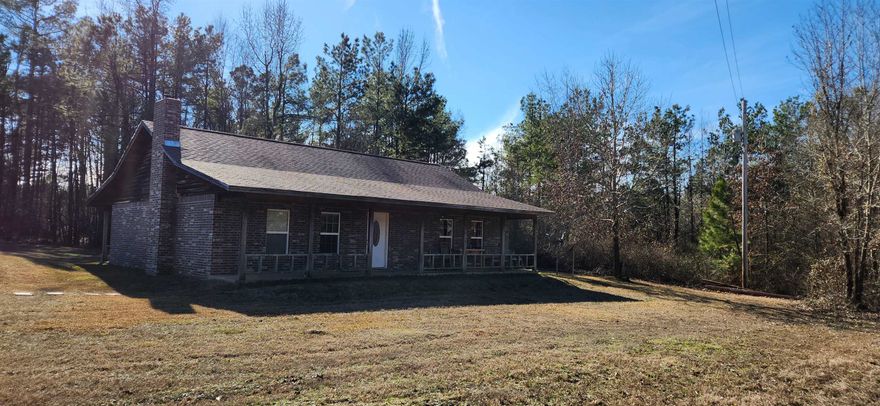 Step into this charming country home and feel the warmth it offers, from the spacious open living and kitchen area to the cozy wood-burning fireplace. nestled in the center of a brick accent wall. The kitchen features granite countertops, and the stove, dishwasher, and microwave are included. The home features durable ceramic tile flooring throughout and boasts freshly painted walls. A brand-new HVAC system was installed in 2023 for added comfort. This home includes a convenient laundry room, two generously sized bedrooms with ample closets, and two bathrooms. The full length front and back porches provides the perfect spots to relax and enjoy the serene countryside views. Situated on  7.35 acres, there’s plenty of space for a garden. This country retreat is ready for its new owner to make it their own!