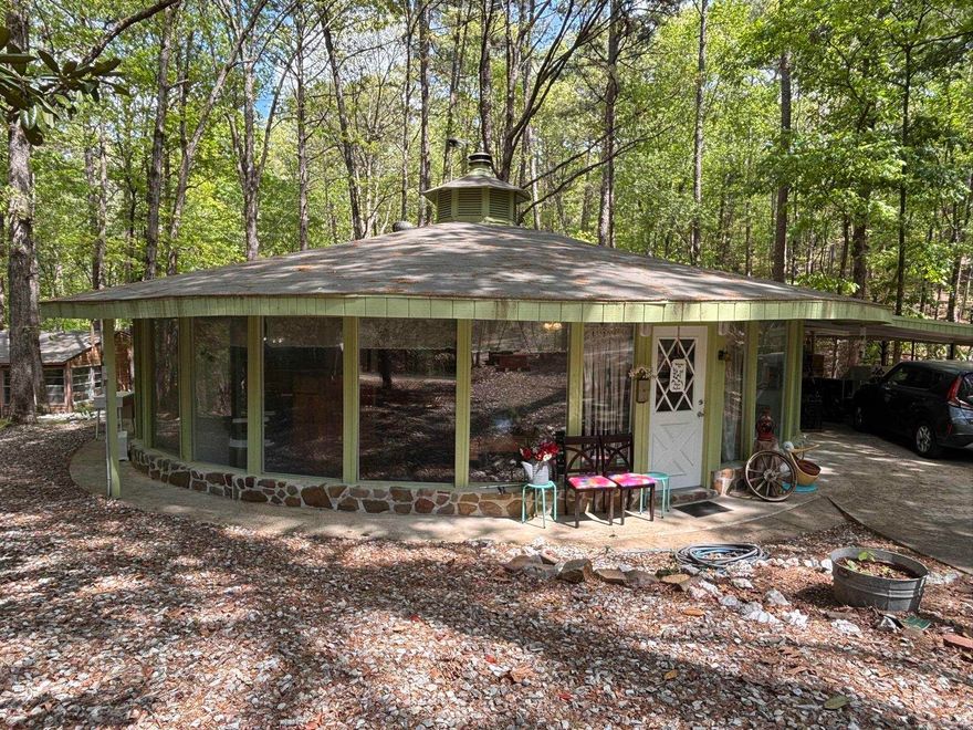 Great location.  Great view.  What a unique home.  Wonderful for starter home or retirees.  Would make an amazing AirBNB.  A true round home in the Village with a 18X20 building with electric behind the home would make a great game room or a hobby shed with new roof 2024 house roof 2021.  New deck.  Wood burning fireplace new cabinets in kitchen with pull outs.  New flooring and great views.  Open Arkansas Room with great views of the area.  Could easily be divided to make a third bedroom.