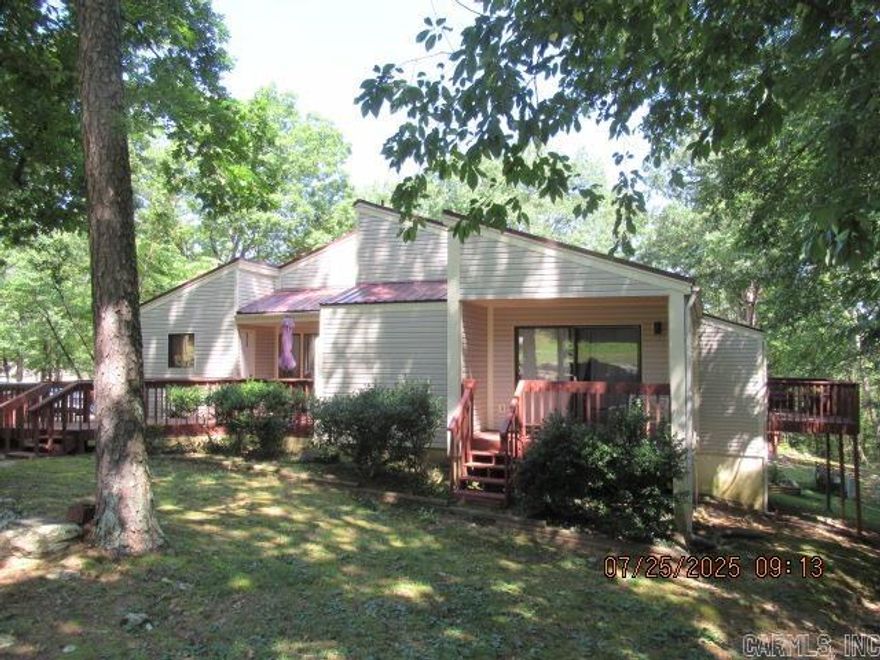 This beautiful end unit in the Terraces might be just what you are looking for, and it has a NEW PRICE.  Not only is it one-level, but with the ramp, you will have NO STEPS. The beautiful kitchen has a new stove, microwave, and refrigerator (with water dispenser), along with tile flooring.  The dishwasher was replaced in 2024.  The one-piece stack washer and dryer is included.  The living/dining areas as well as the bedrooms have hardwood flooring. The largest bedroom is currently used as an office and will accommodate a king-size bed.  Both baths are tile flooring.  The trees all around make it a great place to enjoy the decks with your morning coffee.  Decor and furniture are negotiable.  Call today to start enjoying life in Fairfield Bay!