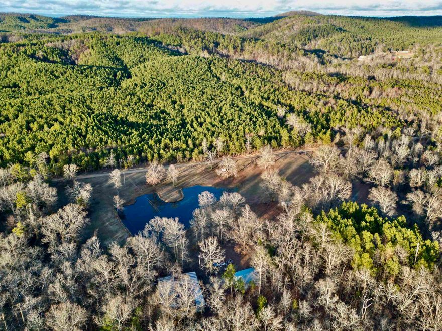 Nestled on 40 acres of unspoiled wilderness, this fenced and gated sanctuary embodies the ultimate hunter's paradise. A picturesque pond glistens amidst the landscape, complemented by two expansive shops, water and electric on-site and a robust year-round creek that meanders through the property, accentuating a thoughtfully designed trail system. Offering county road frontage and perfect sites for constructing your dream home, this private haven teems with abundant wildlife, inviting you to revel in the serenity and untamed beauty of this country property.